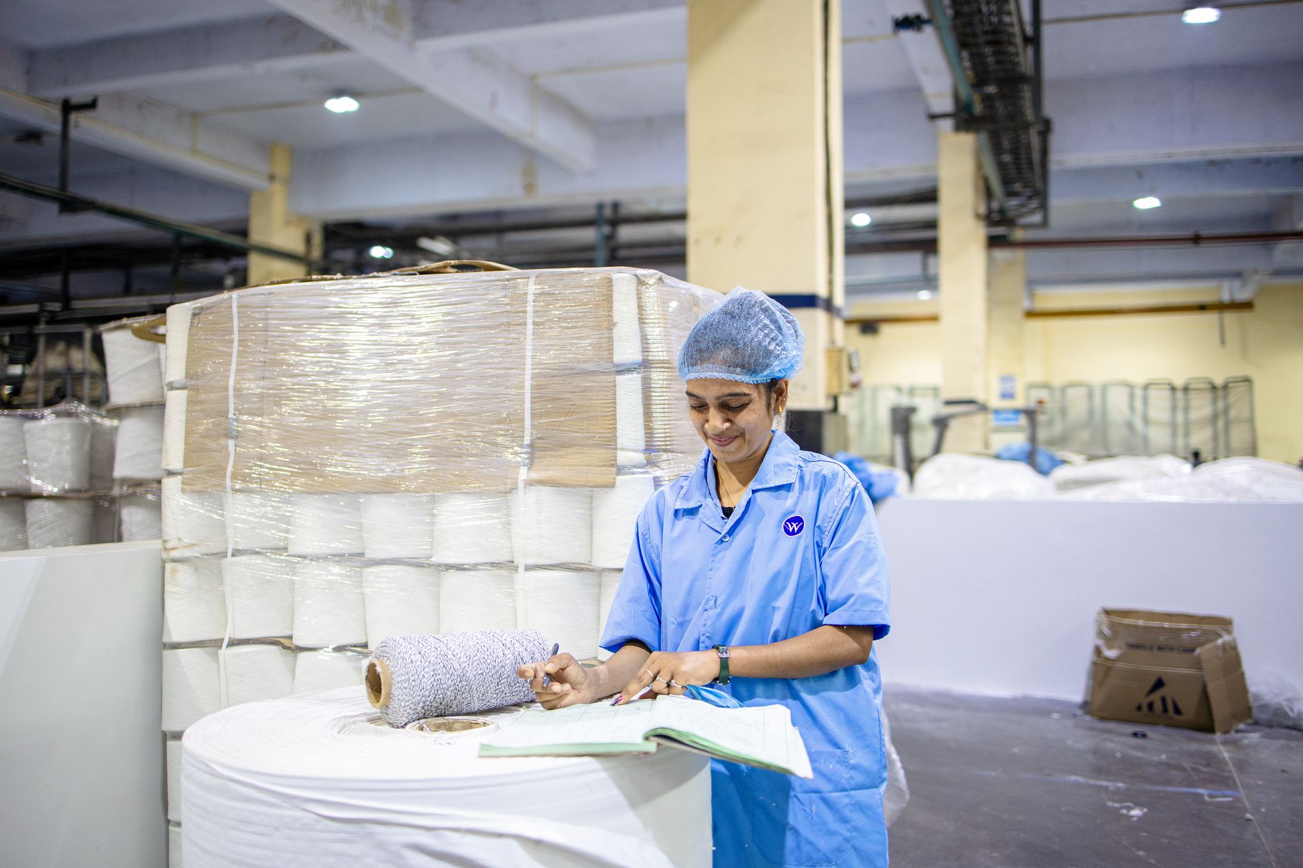 Spill response supplies staged near a production area where drips and crushed cartons still happen.