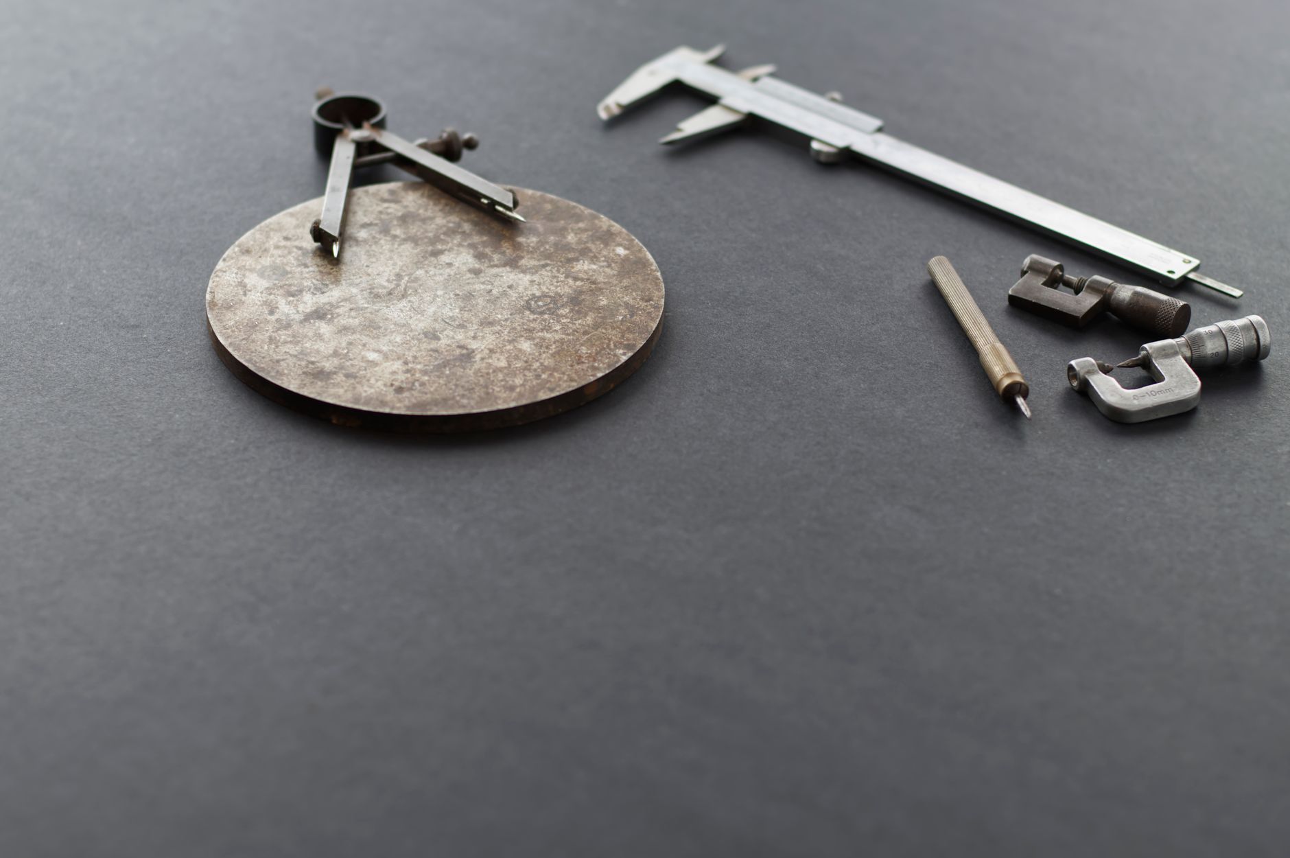 Calipers and gauges on a metal part like those used to qualify bore diameter before press-fit insertion.