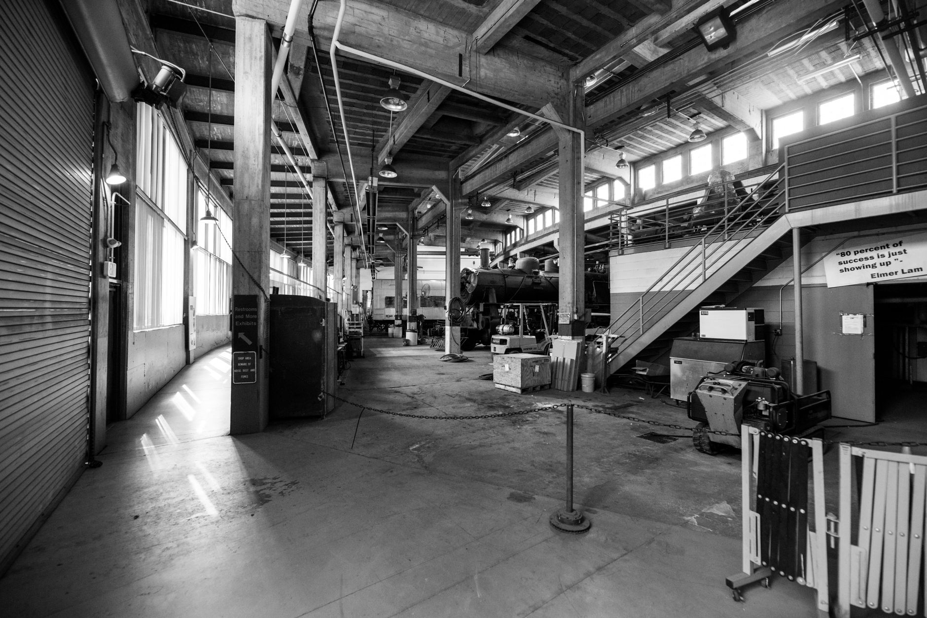 Interior of an industrial concrete plant bay with harsh overhead lighting typical of precast production.