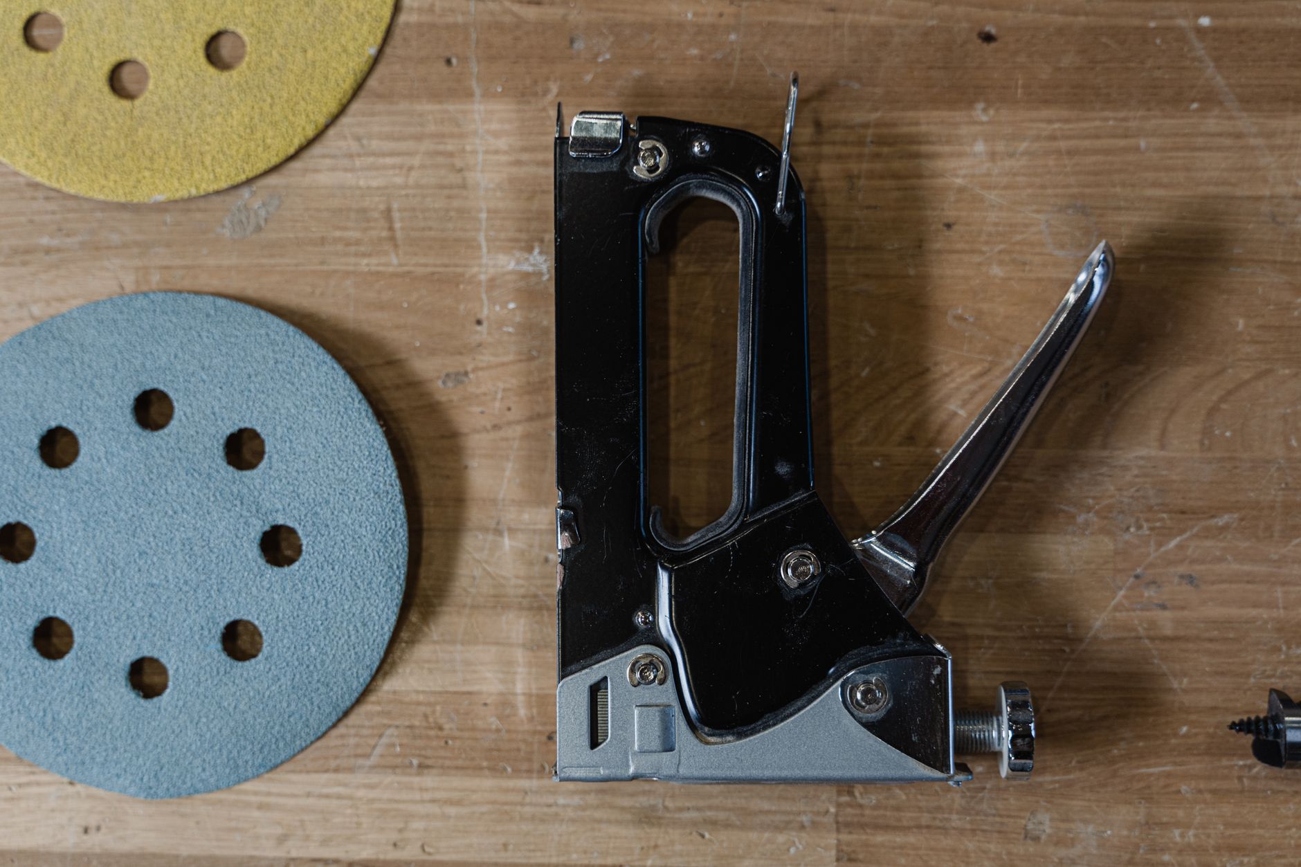 Sanding discs arranged at a workstation for controlled abrasive changes between panel-finishing passes.