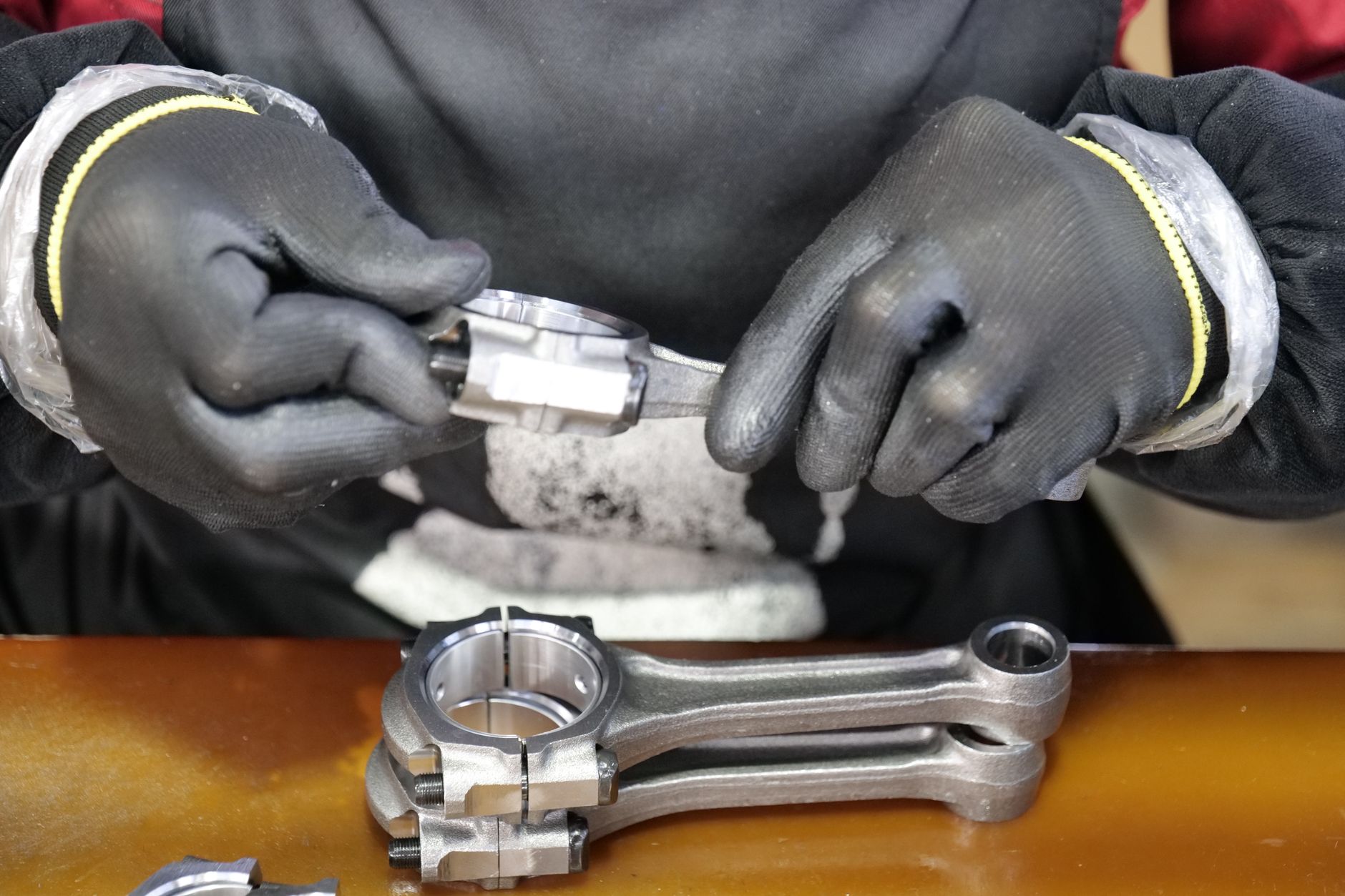 Shop-floor scene of metal part finishing at a deburring bench, reinforcing the safety and ergonomic risks that retrofit automation can help remove from repetitive tasks.