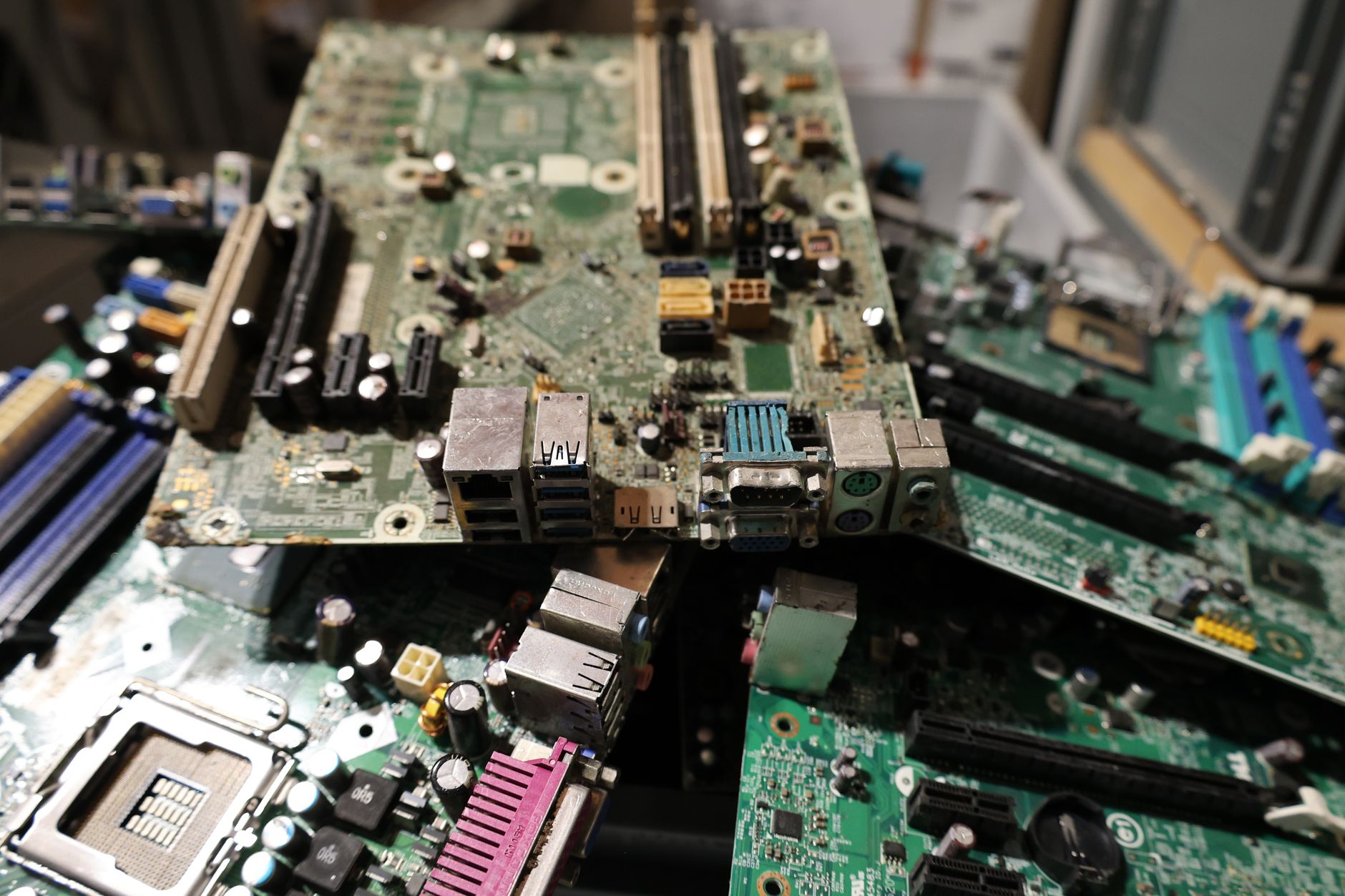 A mixed pile of exposed circuit boards, connectors, and electronic components awaits identification and sorting.