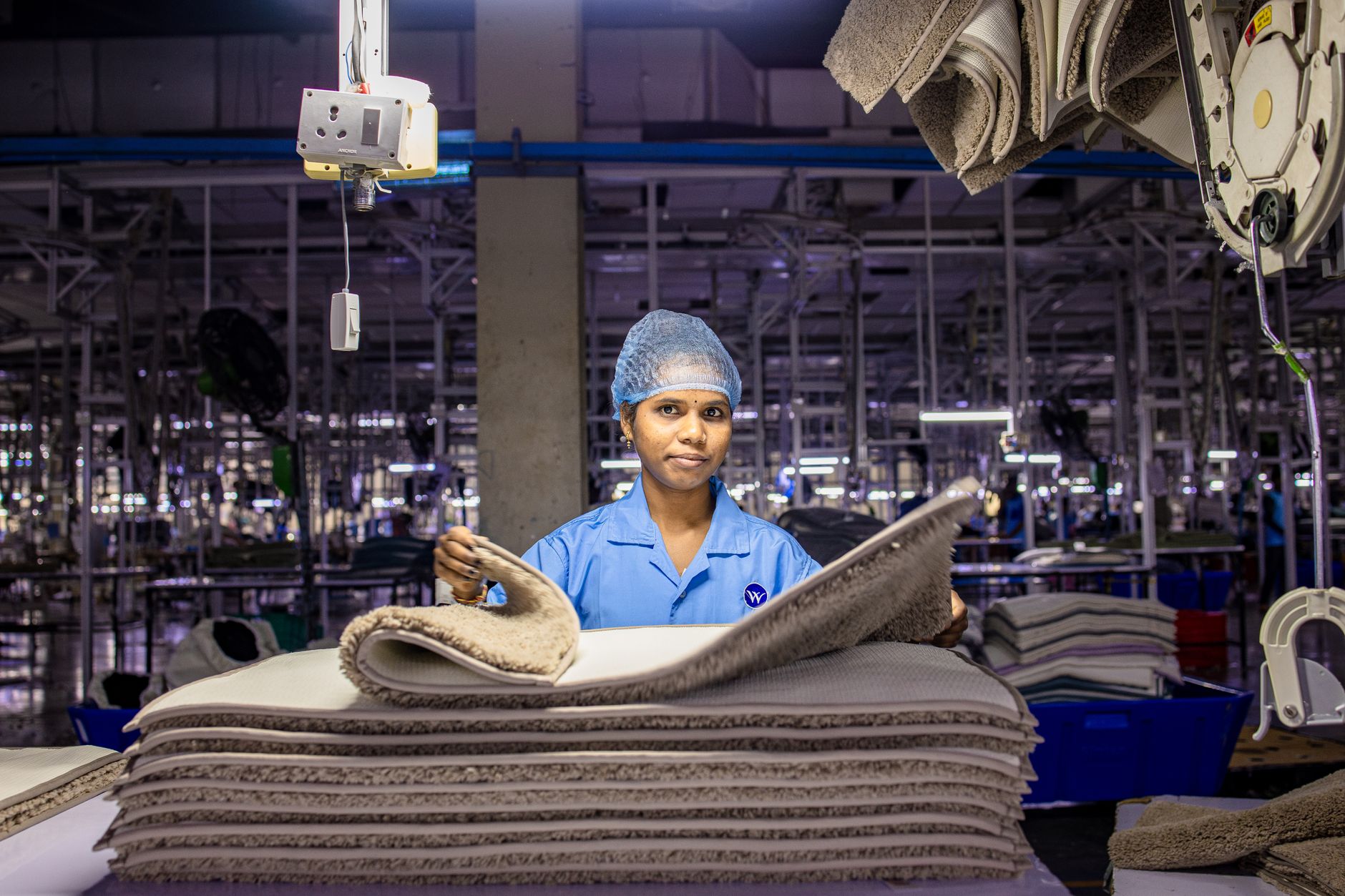 A trained recycling worker inspects uncertain electronic components at a sorting station.