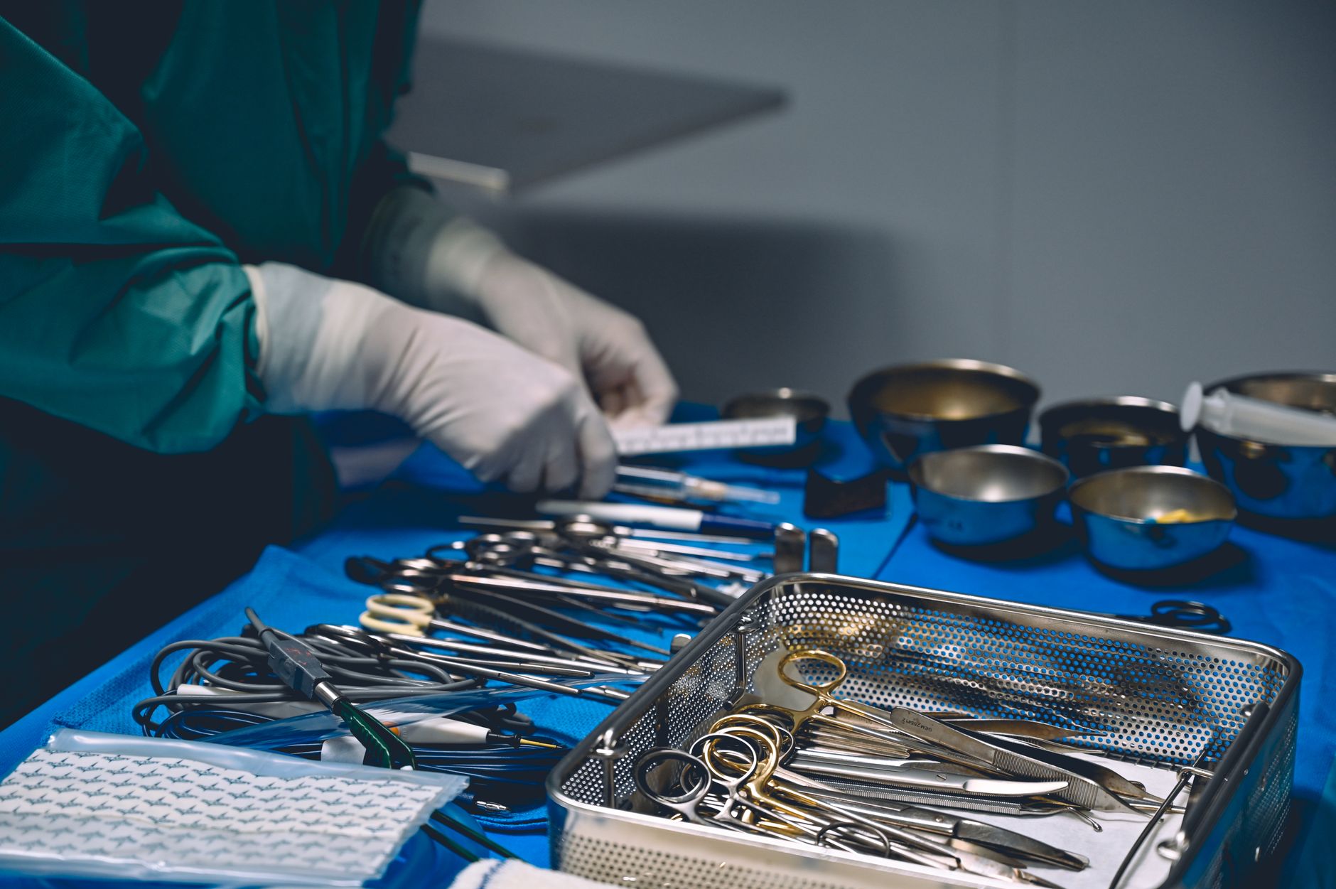Metal surgical instruments arranged on a tray, illustrating the mix a sort cell must identify correctly.