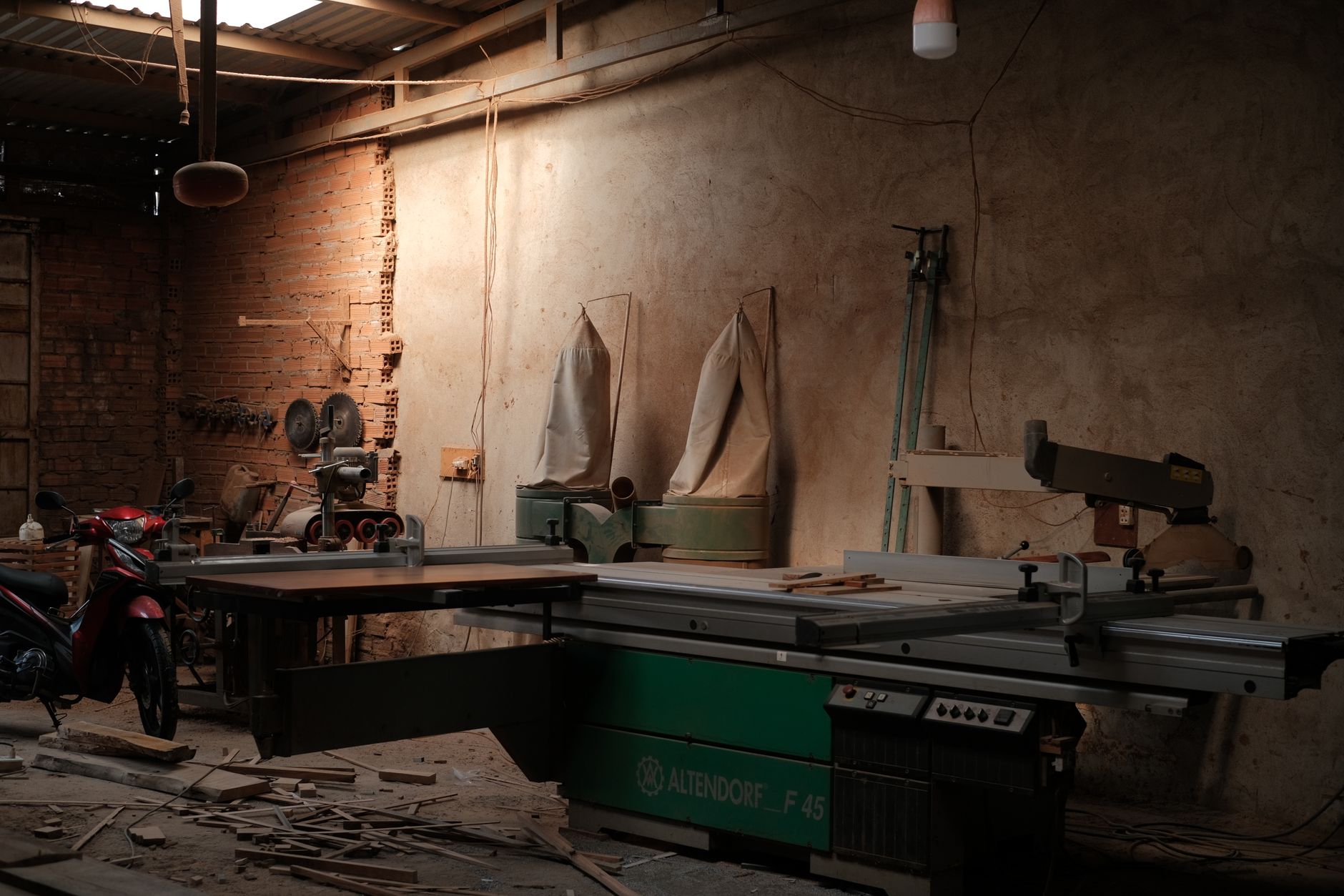Workers assembling upholstered furniture frames in a bright factory workshop.