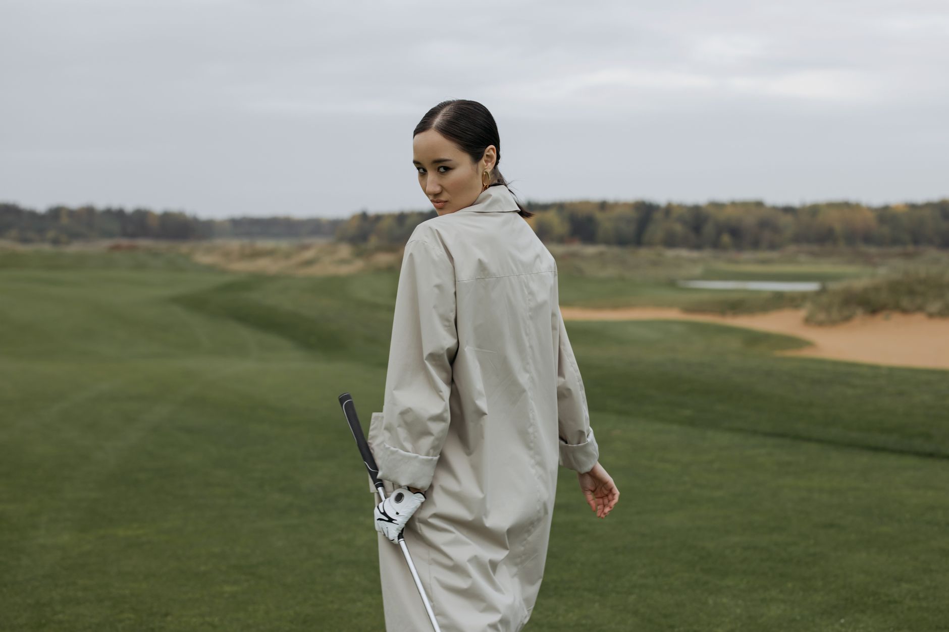 Wind bending grass along an open golf fairway