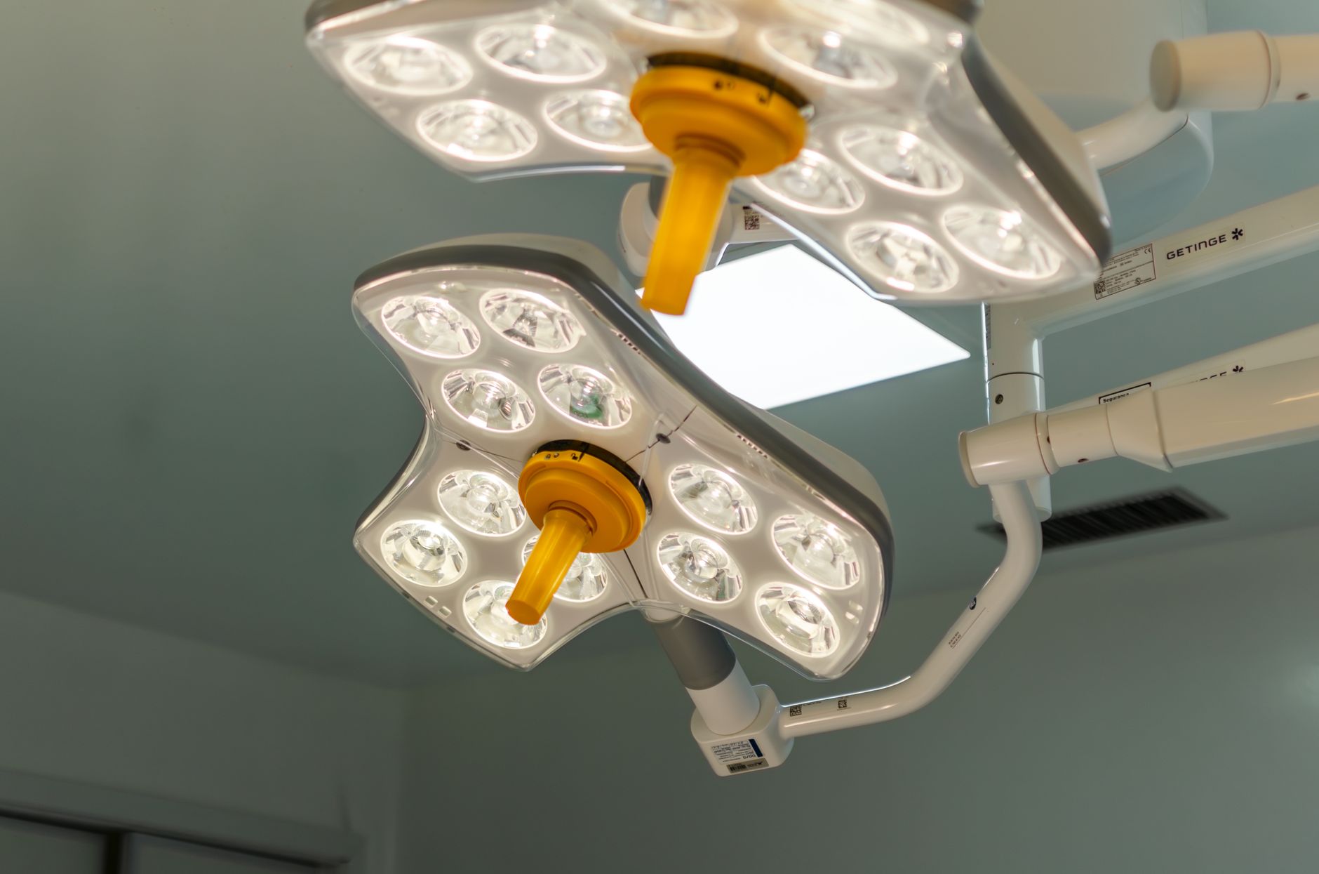 Facilities staff working above a hospital ceiling, reflecting the building access required for tube-system expansion.