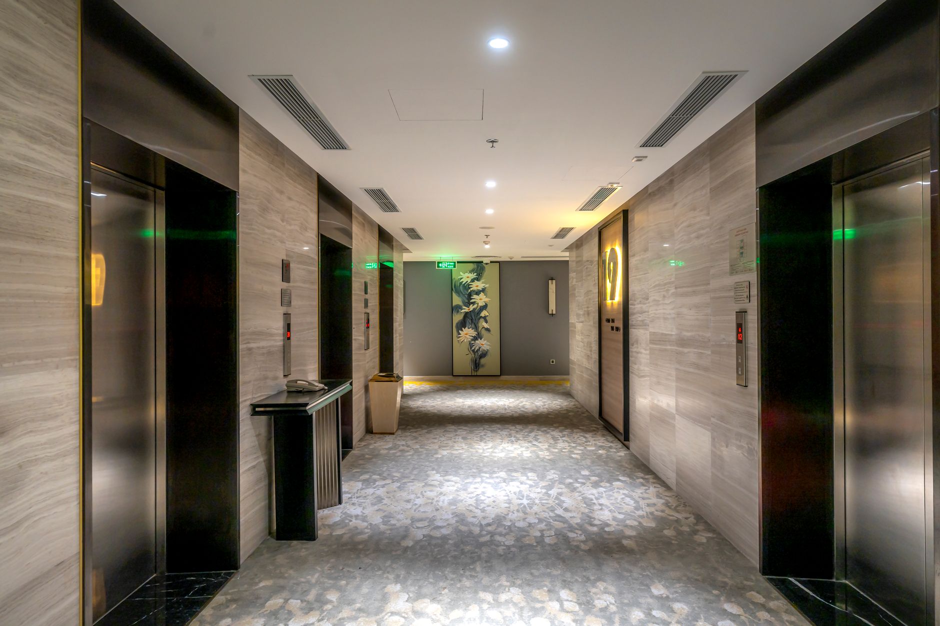 A busy hospital service elevator area where traffic, carts, and door timing affect internal transport reliability.