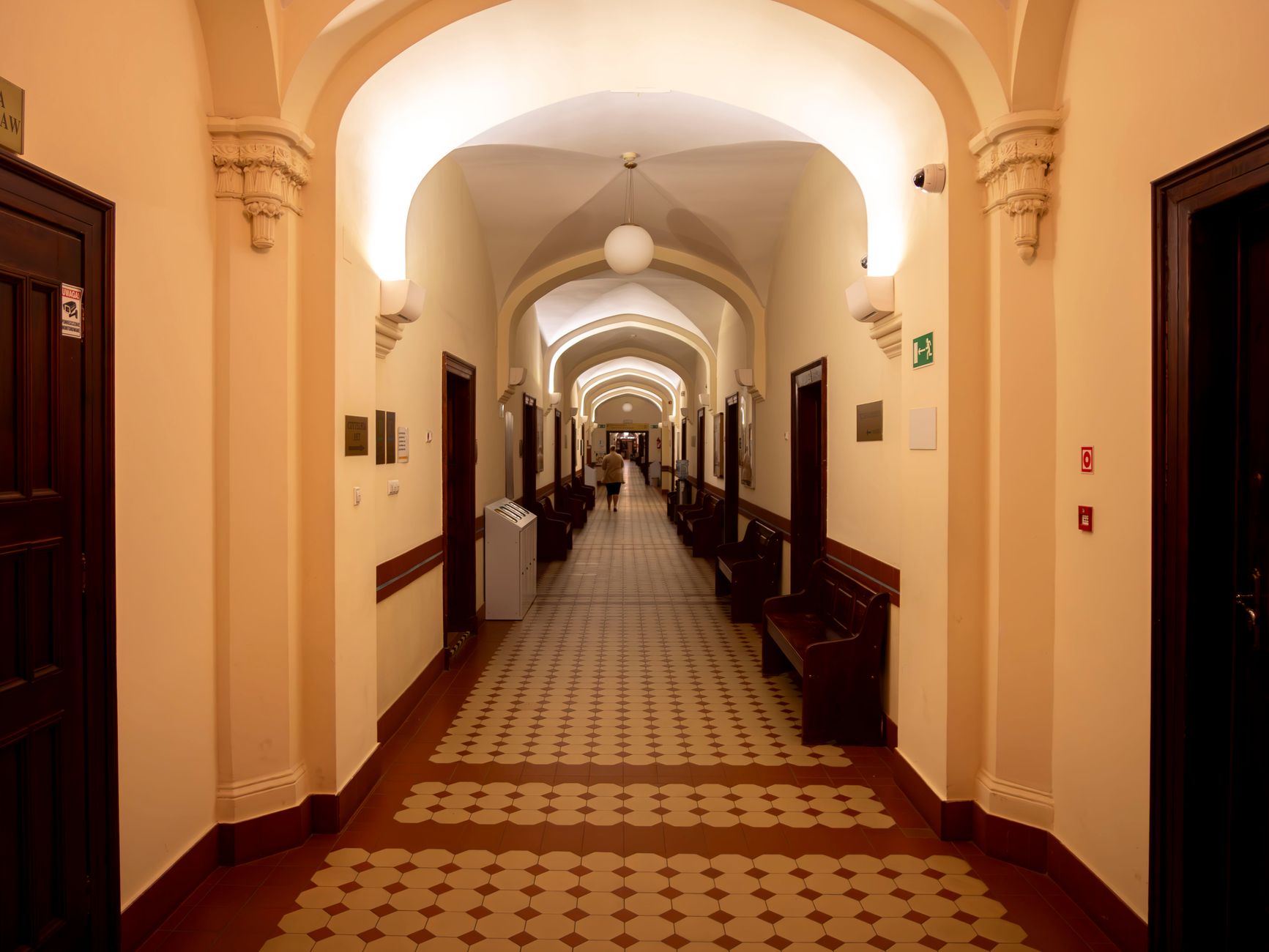 Long office corridor typical of a multi-floor legal campus where internal deliveries run all day.