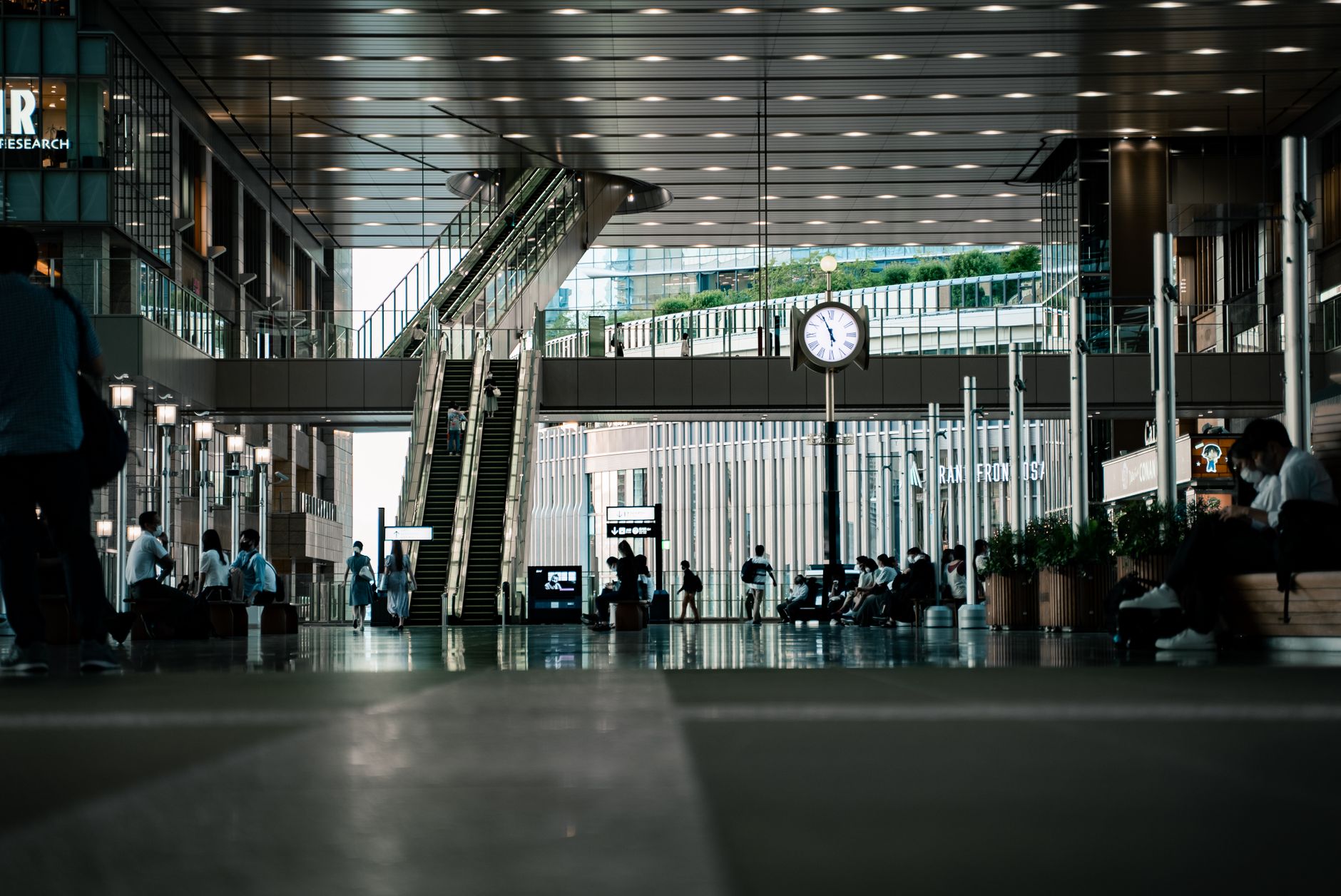 Travelers moving through a bright public concourse where clear wayfinding cues matter.