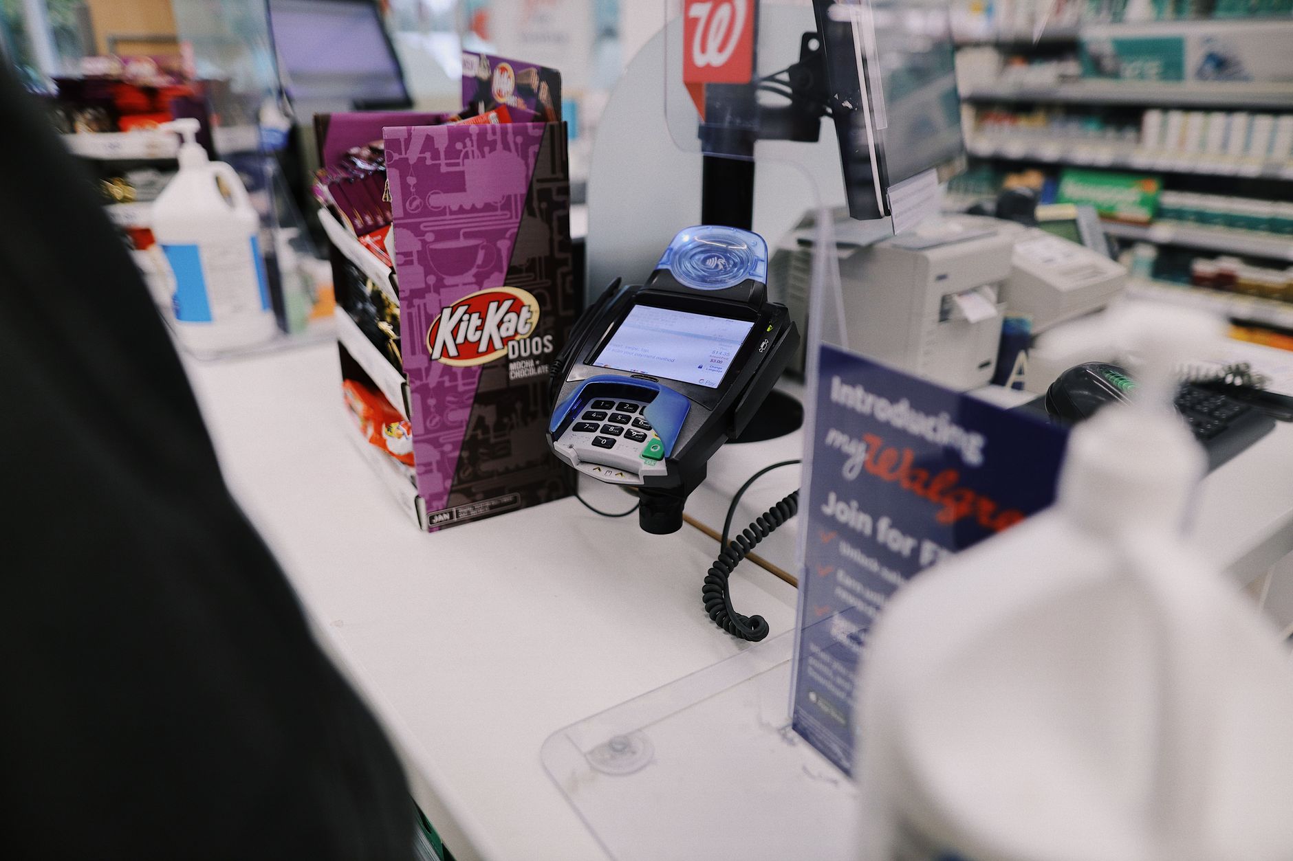 A pharmacy front counter and surrounding hard floor late in the day, reflecting the closing work that competes with cleaning.