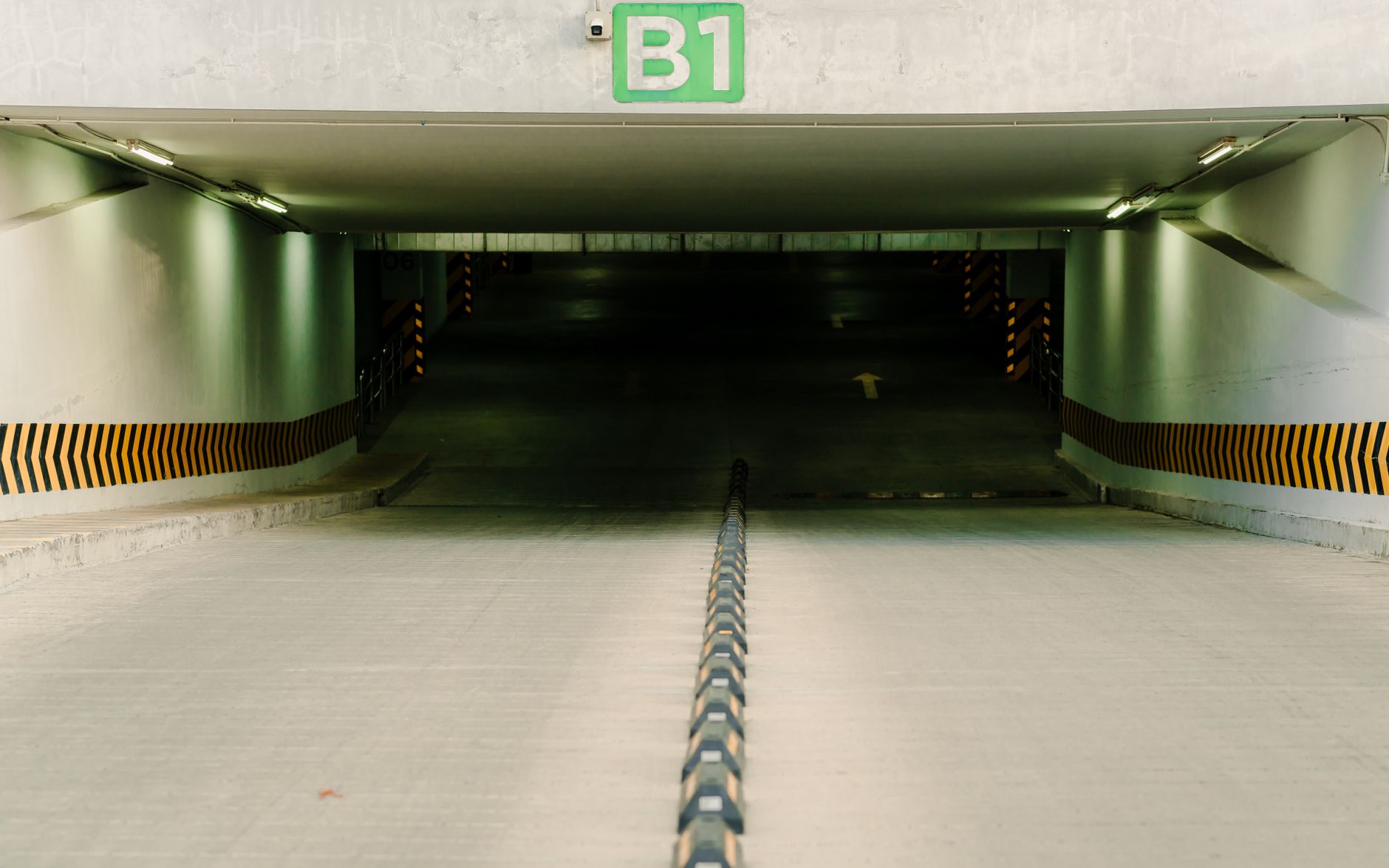 Accessible parking spaces and striped access aisles inside a garage, highlighting clearance and route requirements that security operations must preserve.