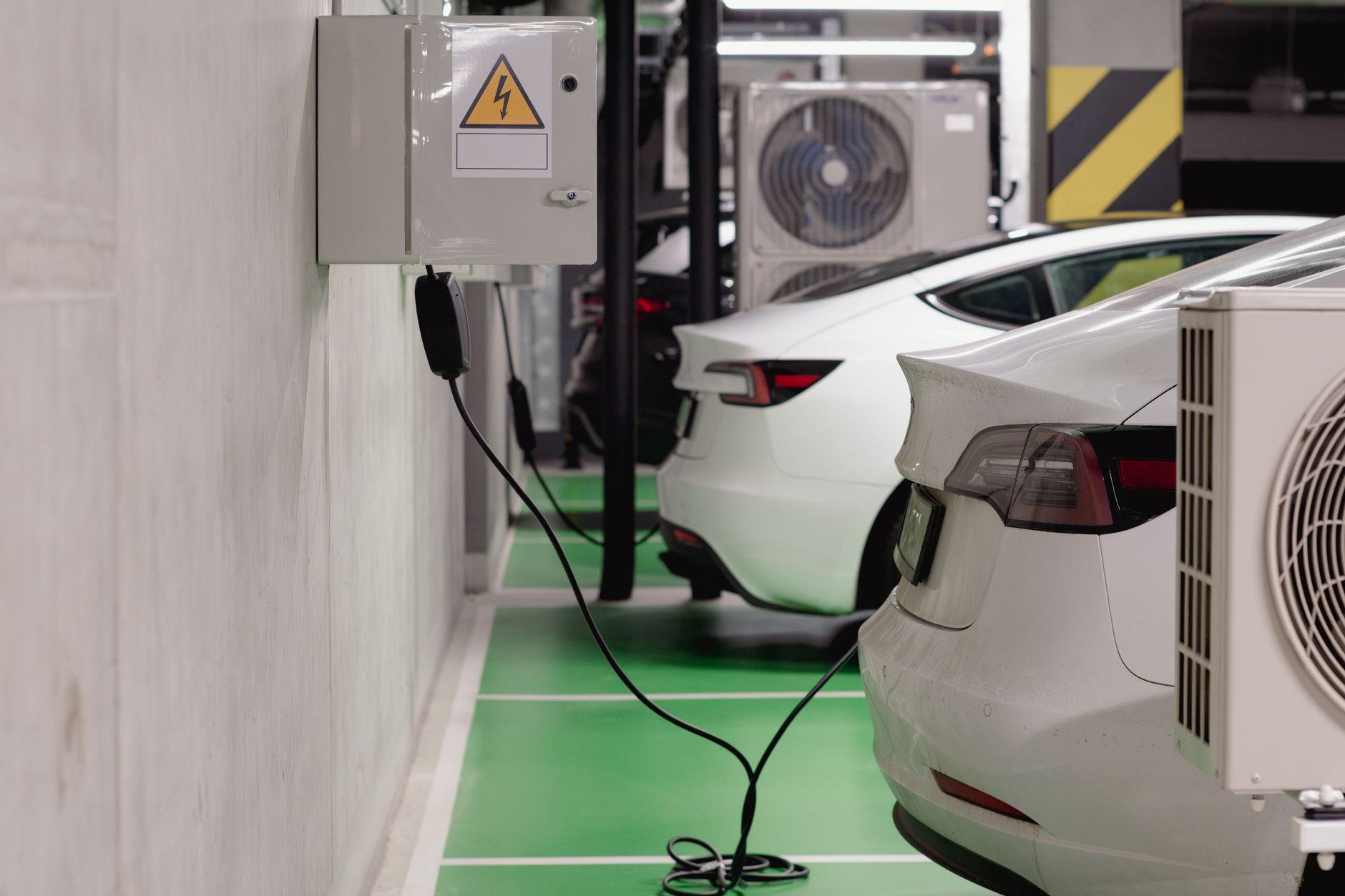 Electric vehicle charging area inside a commercial parking garage, representing the added equipment zones and guest assistance needs described in the article.