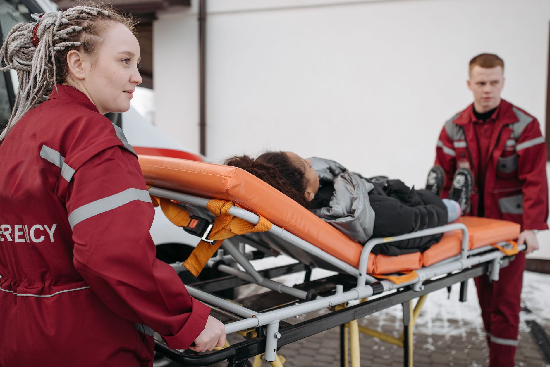 Paramedics move a patient on a stretcher, illustrating the dispatch-to-handoff workflow behind prehospital blood use.