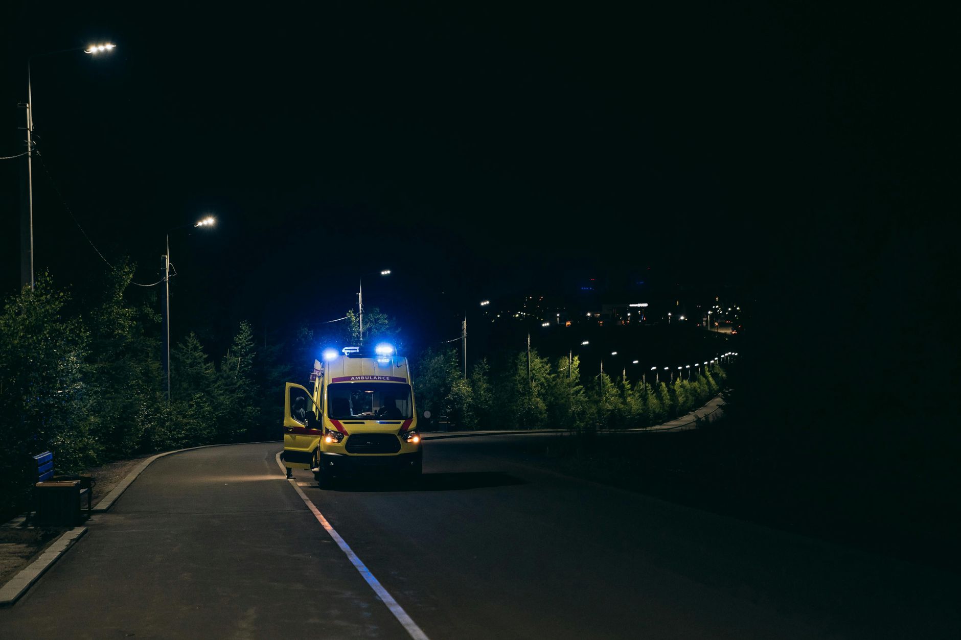 Emergency responders work around an ambulance at night, matching the article's focus on getting lifesaving blood to trauma scenes fast.