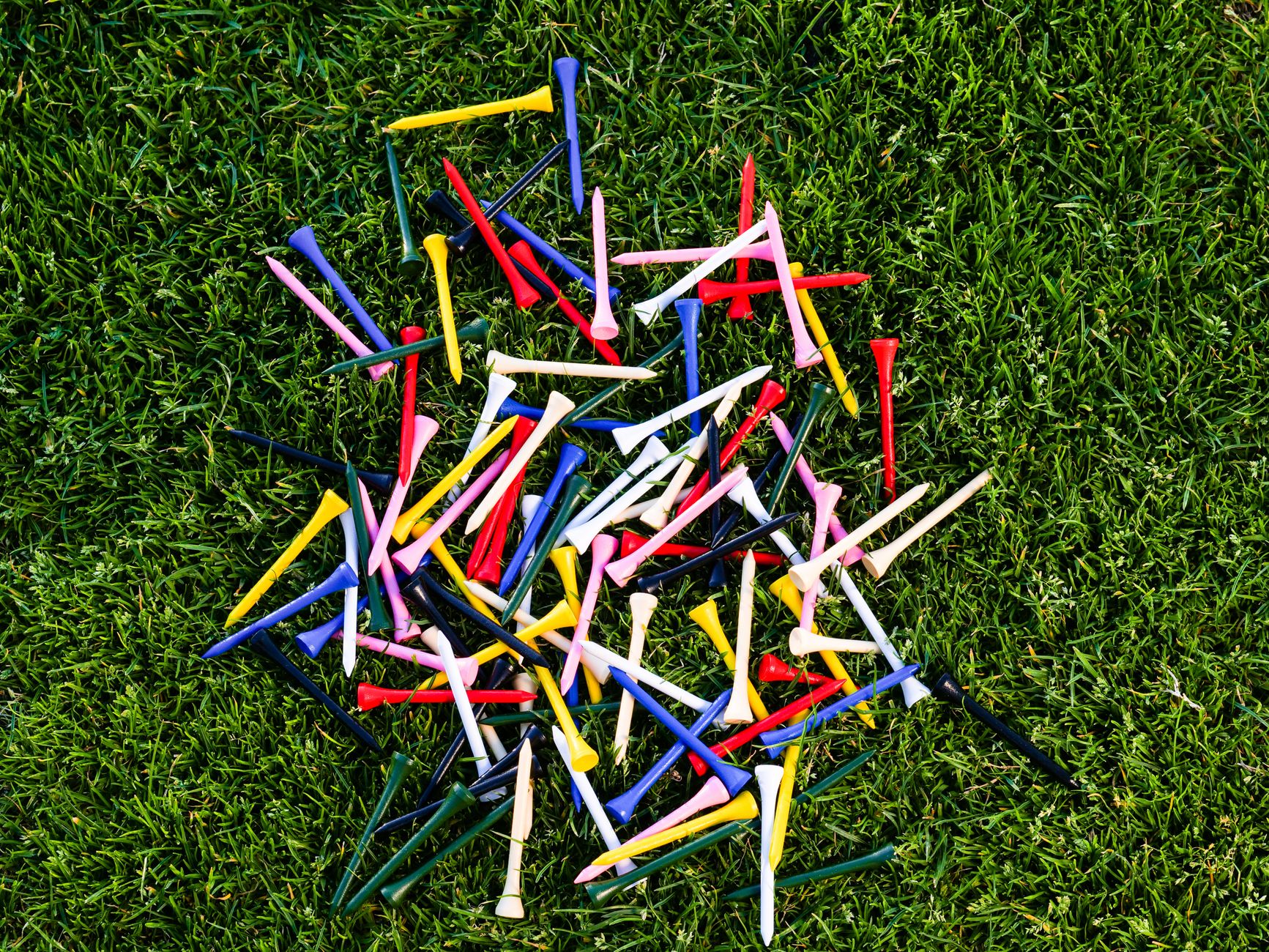 Golf tee markers and a scorecard on a practice tee.