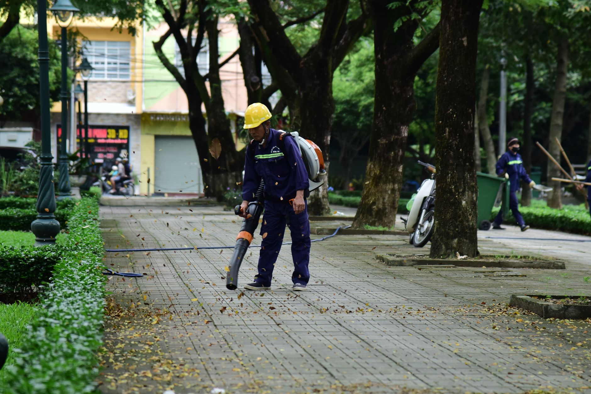 Worker blowing leaves off a turf area