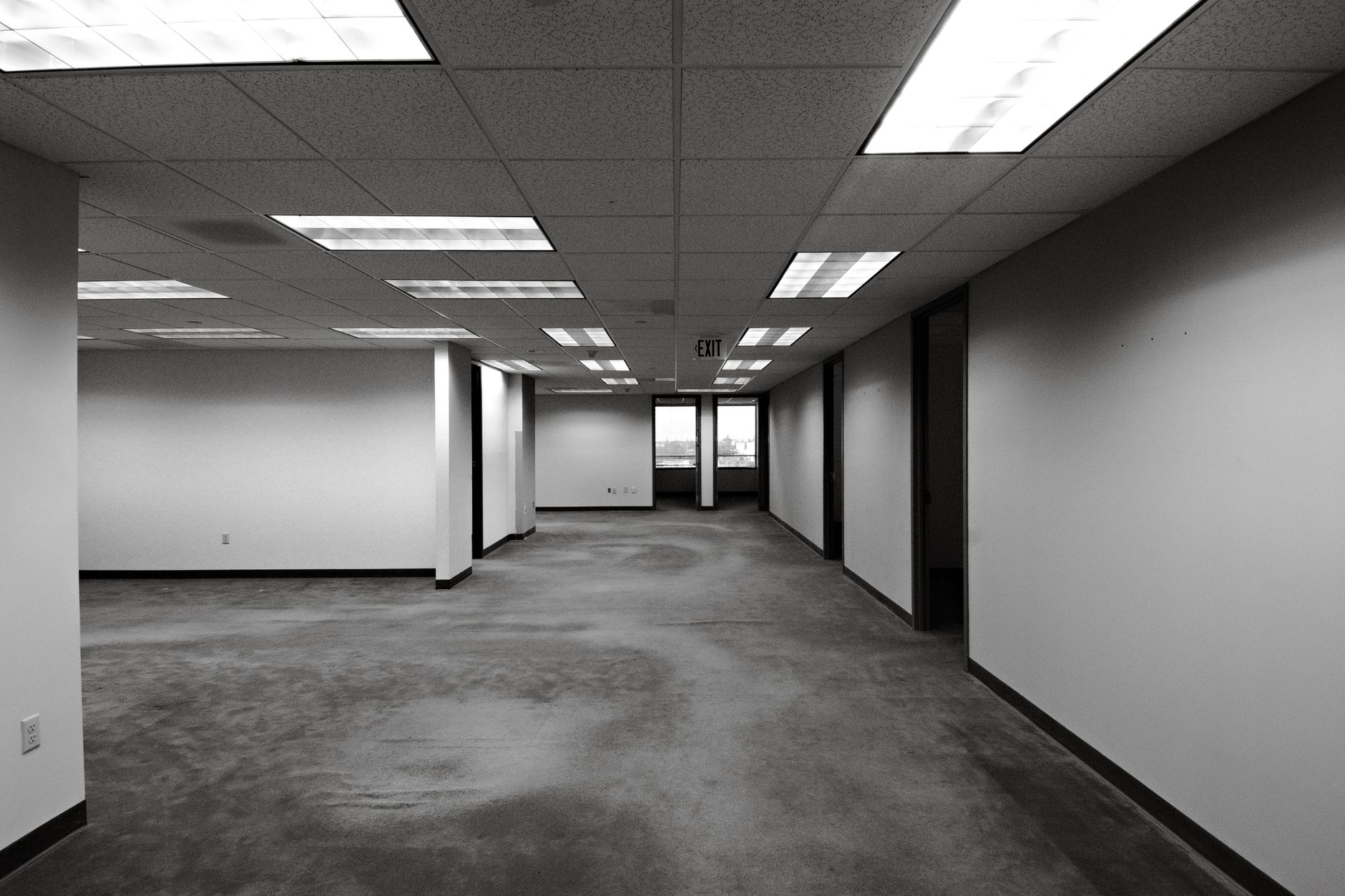 A clean office corridor showing a smooth transition from low-pile commercial carpet to polished tile flooring.