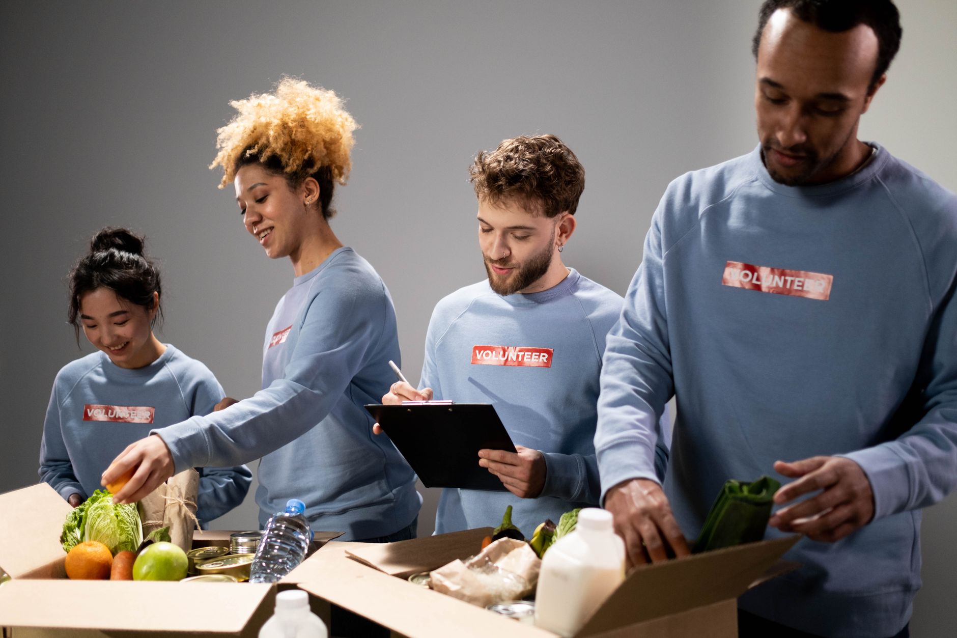 Volunteers sort donated food inside a busy community food bank.