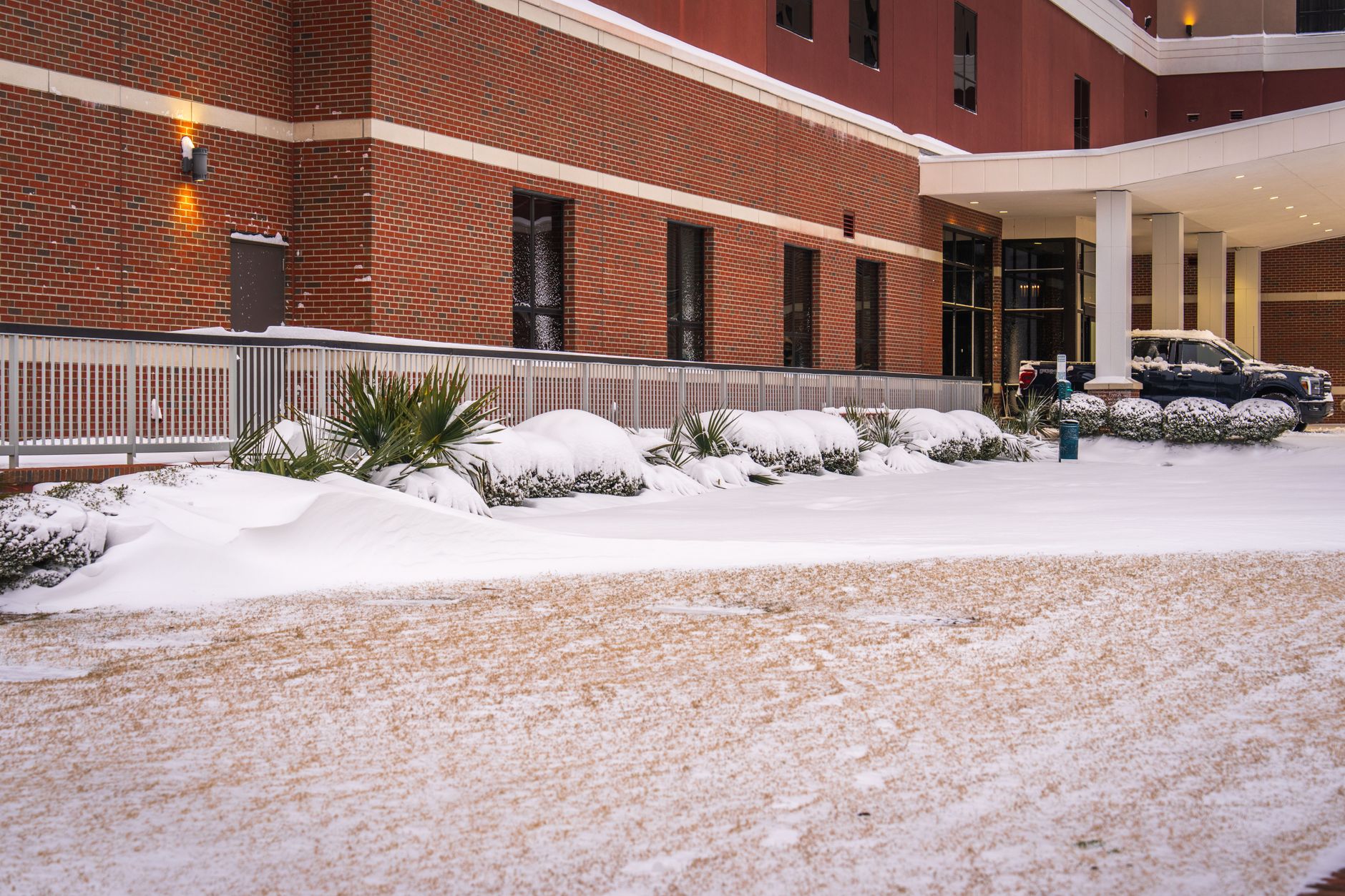 A snow-covered commercial building entrance where tracked salt and meltwater must be contained.