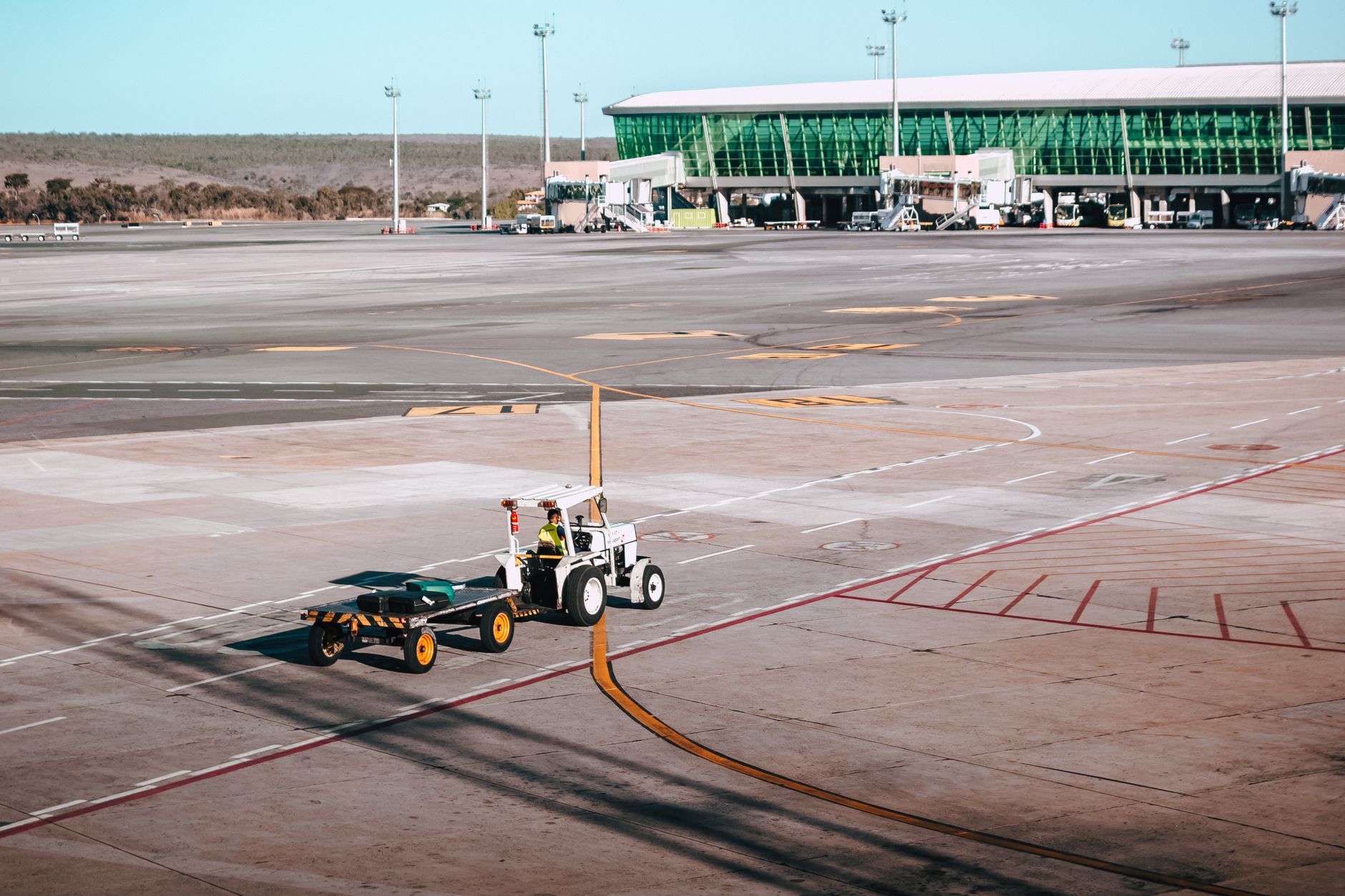 Luggage moves along a complex conveyor belt system in the baggage handling area of an airport.