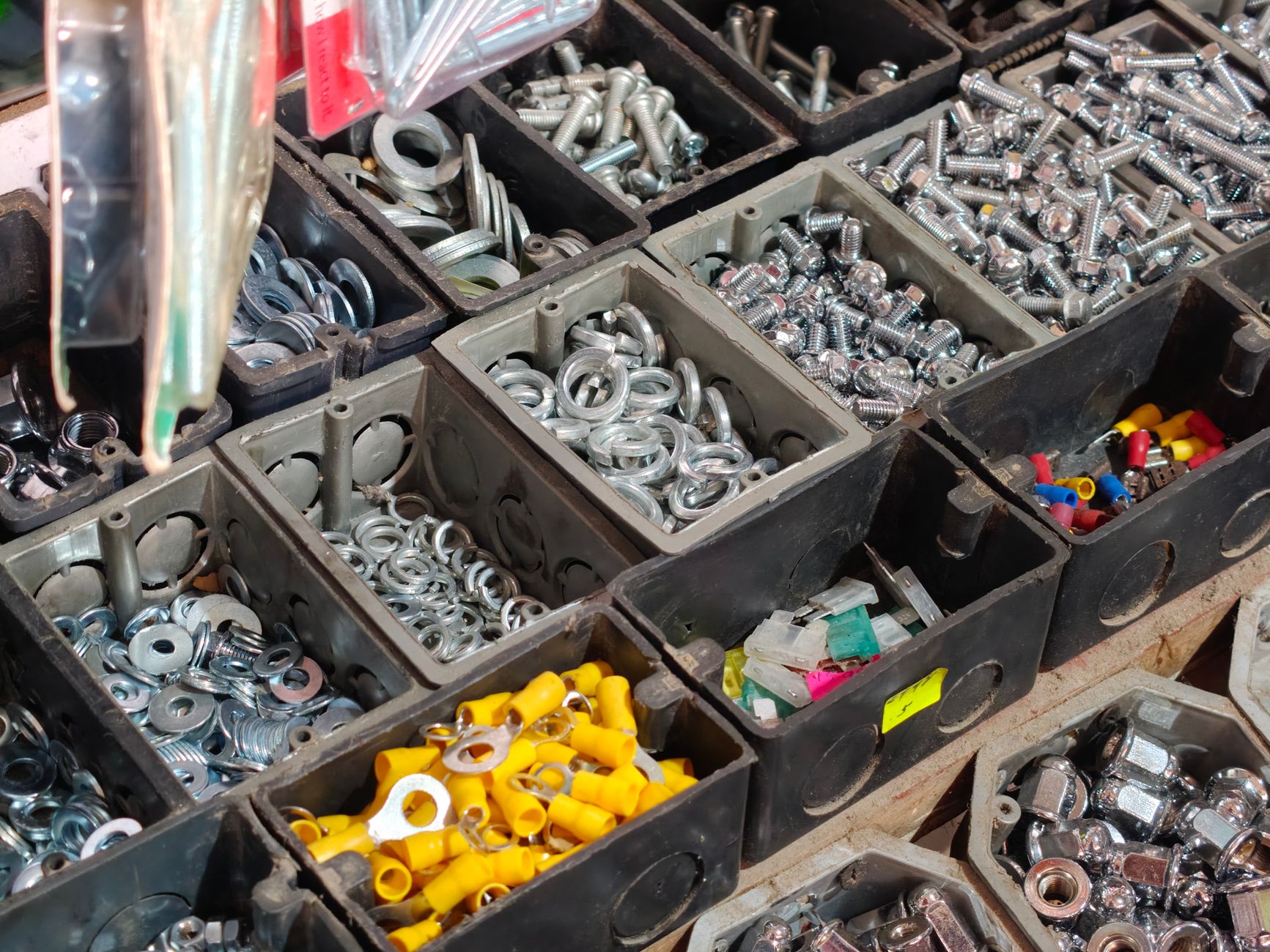 A large bin filled with a jumble of complex metal components, illustrating a typical bin-picking task for a cobot guided by a vision sensor.