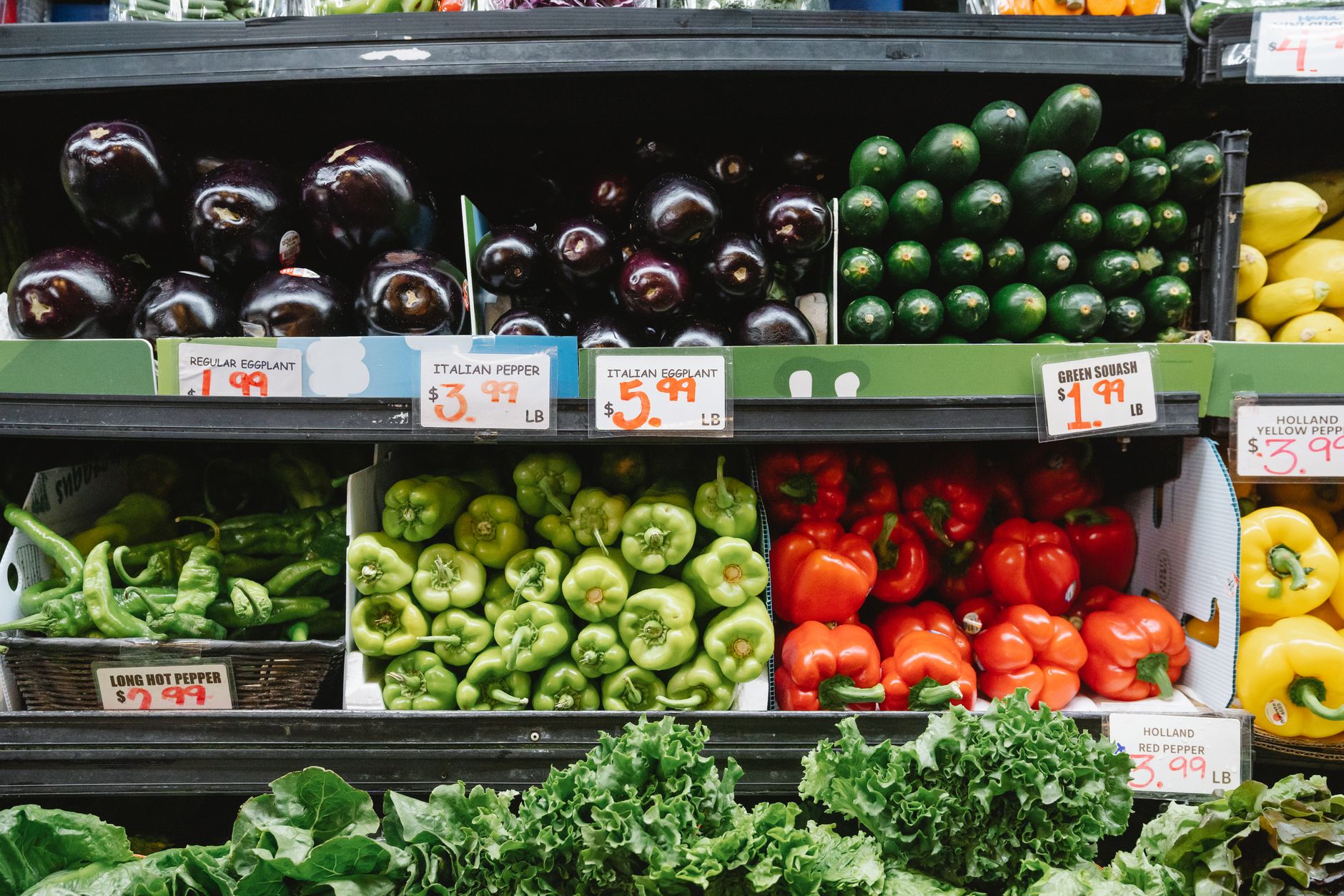A clean floor in the fresh produce section of a grocery store, with colorful vegetables neatly displayed.