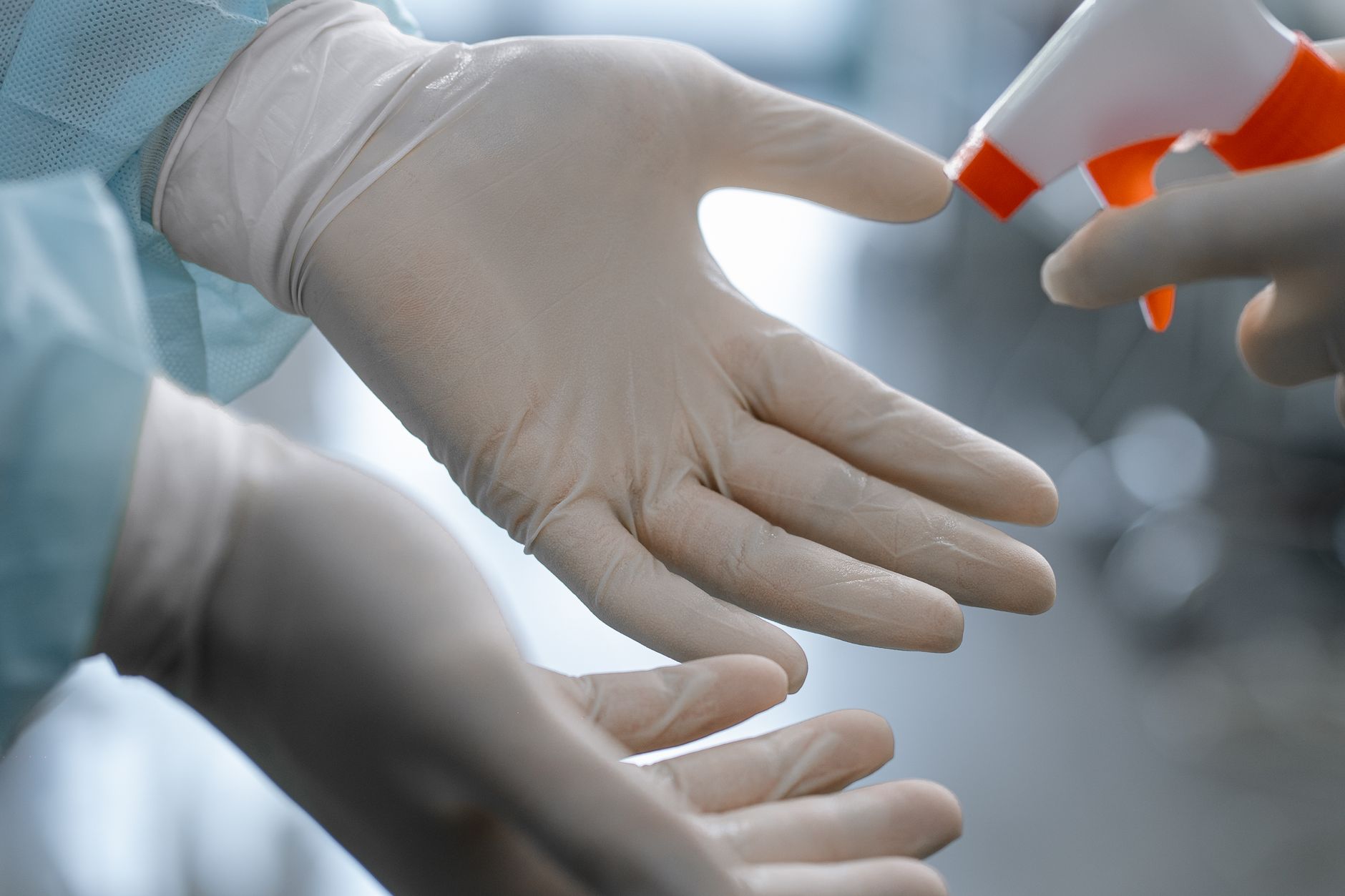 A gloved hand wiping a hospital surface, reflecting wipe-down protocols for shared equipment between trips.