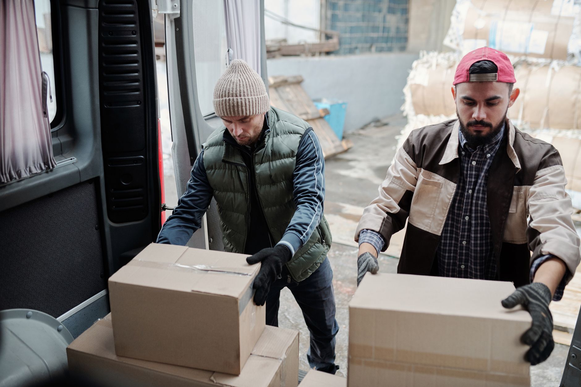 Workers packing boxes at a busy packing station, reflecting the labor pressure that pushes mid-sized plants to reconsider repetitive packaging work.