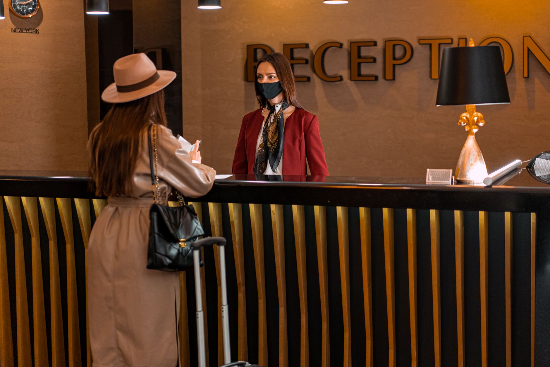 Hotel lobby with suitcases near the front desk where tagged bags begin a lobby-to-room route.