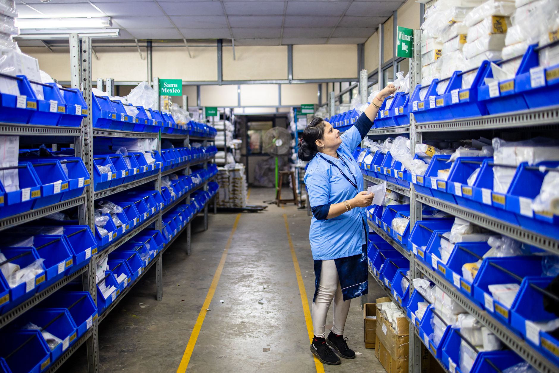 A hotel employee checks storeroom inventory while tracking the accuracy and timing of minibar replenishment.