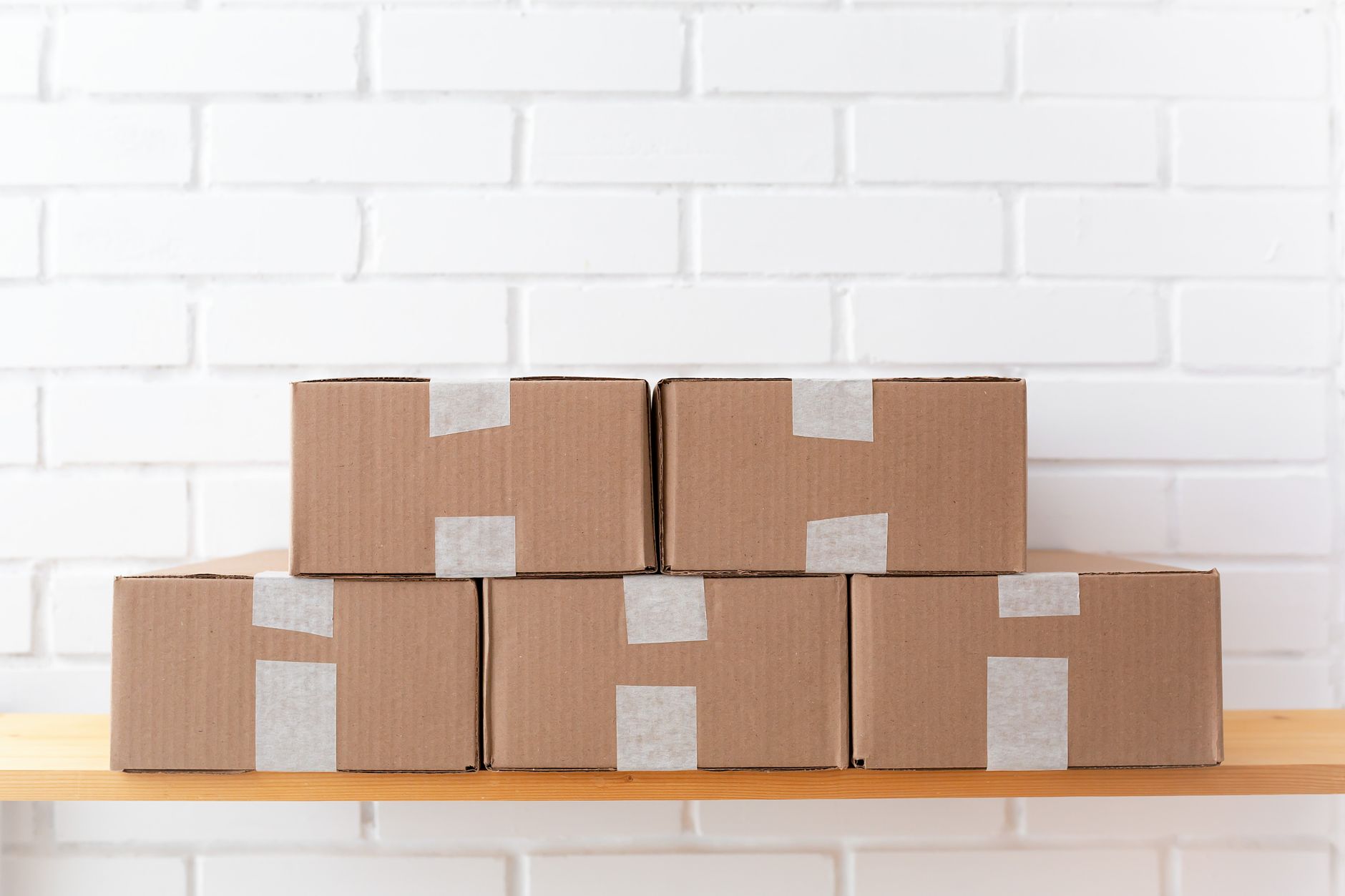 Stacks of sealed cardboard boxes on a pallet, representing high-volume e-commerce orders ready for shipment from a fulfillment center.