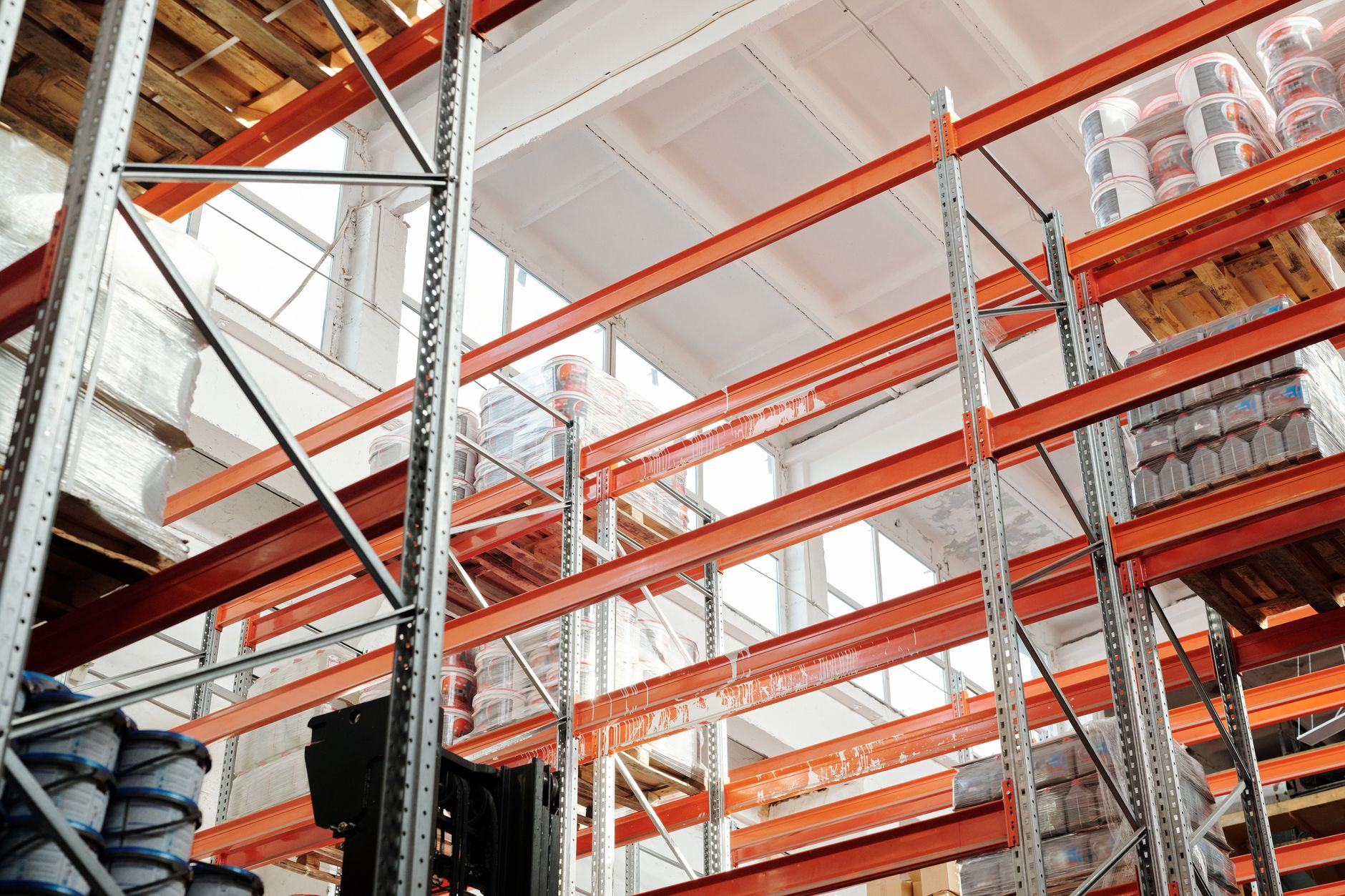 A wide, clean, and brightly lit aisle in a modern warehouse, with tall, orderly shelves ready for inventory.