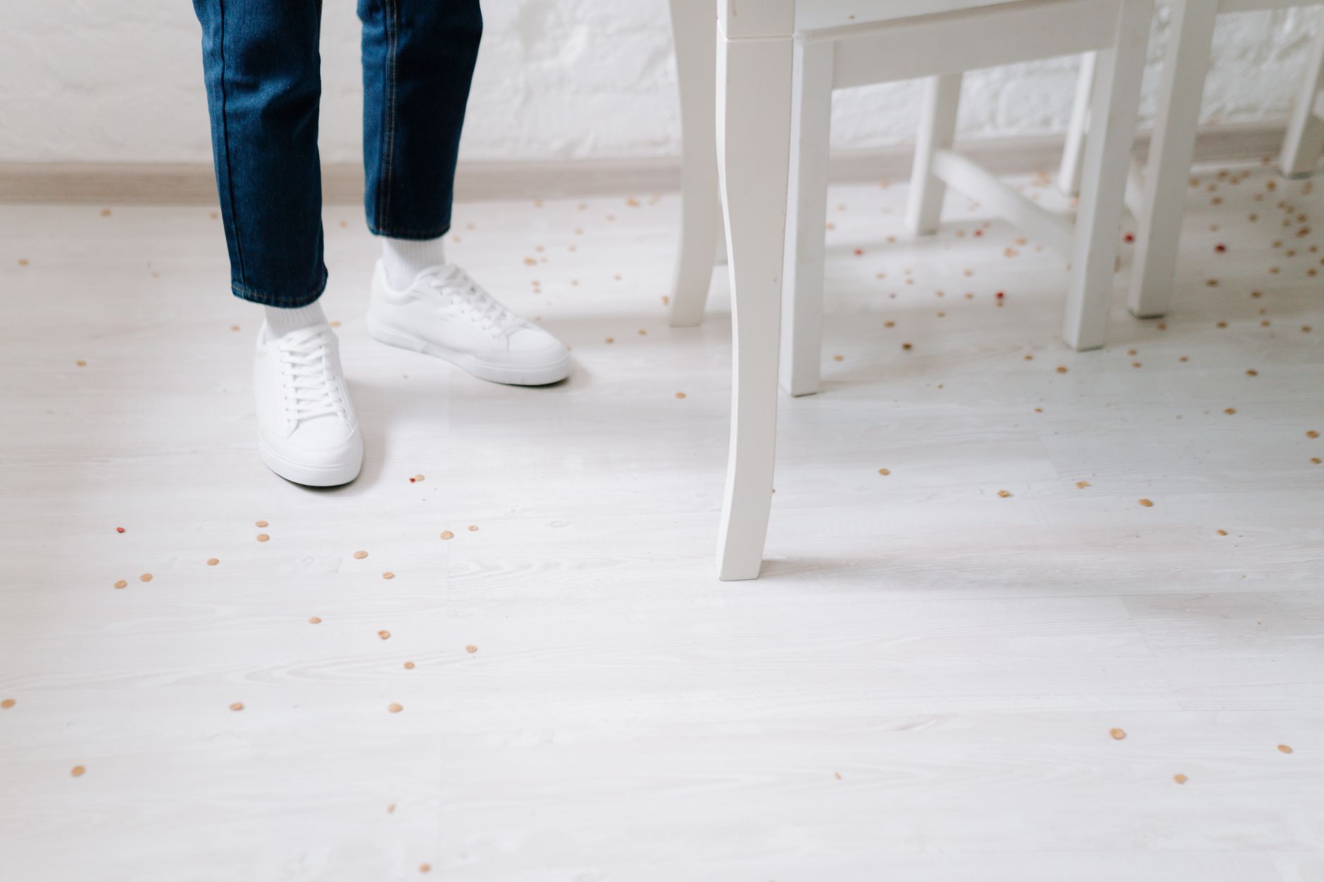 A worker uses absorbent materials to contain and clean a liquid spill on a retail floor.