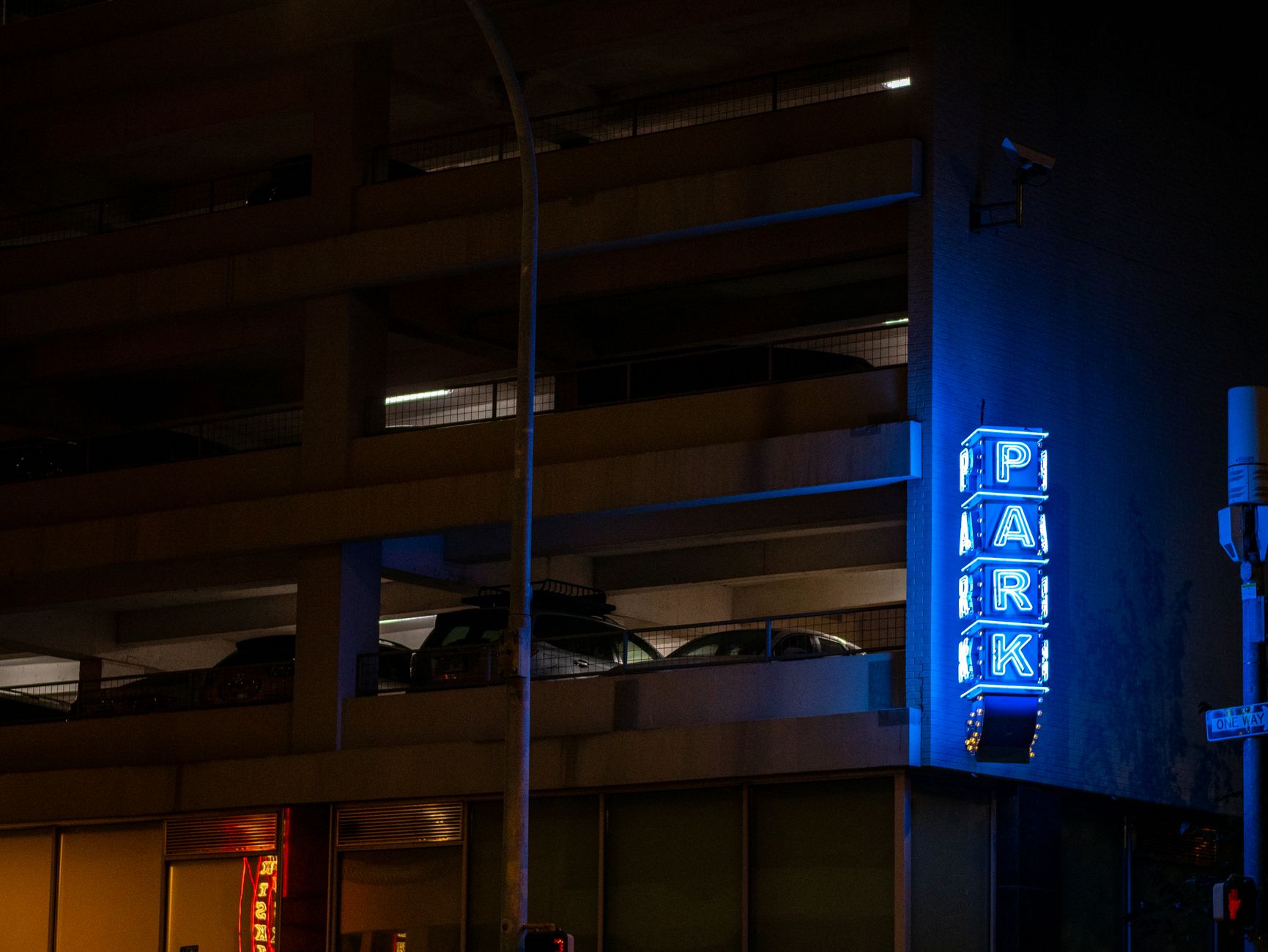 An empty, well-lit university parking garage at night, a common area for autonomous security patrols.