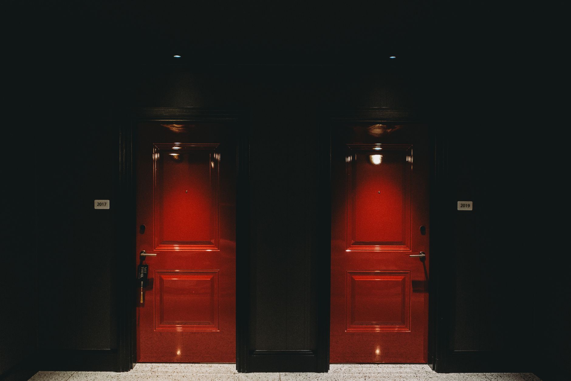 A view down a well-lit hotel corridor, representing the path a delivery robot takes to a guest's room.