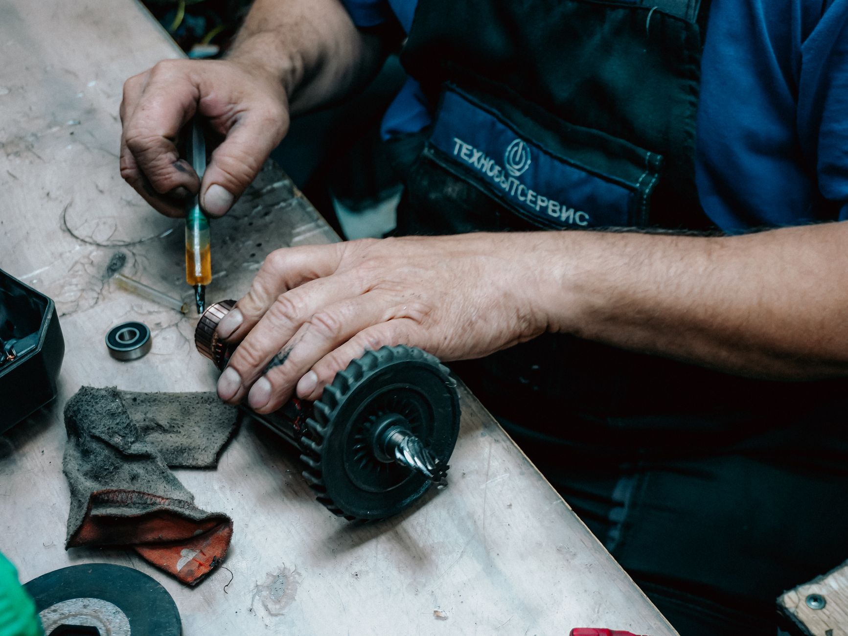 A close-up of a technician's hands carefully performing maintenance on a clean piece of equipment, symbolizing preventative care.
