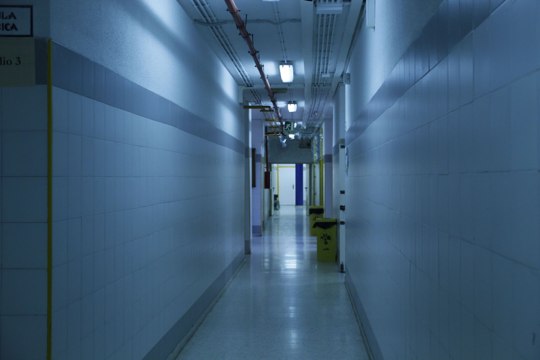 A long, sterile hospital corridor, illustrating an environment where a failed delivery robot could delay critical supplies.