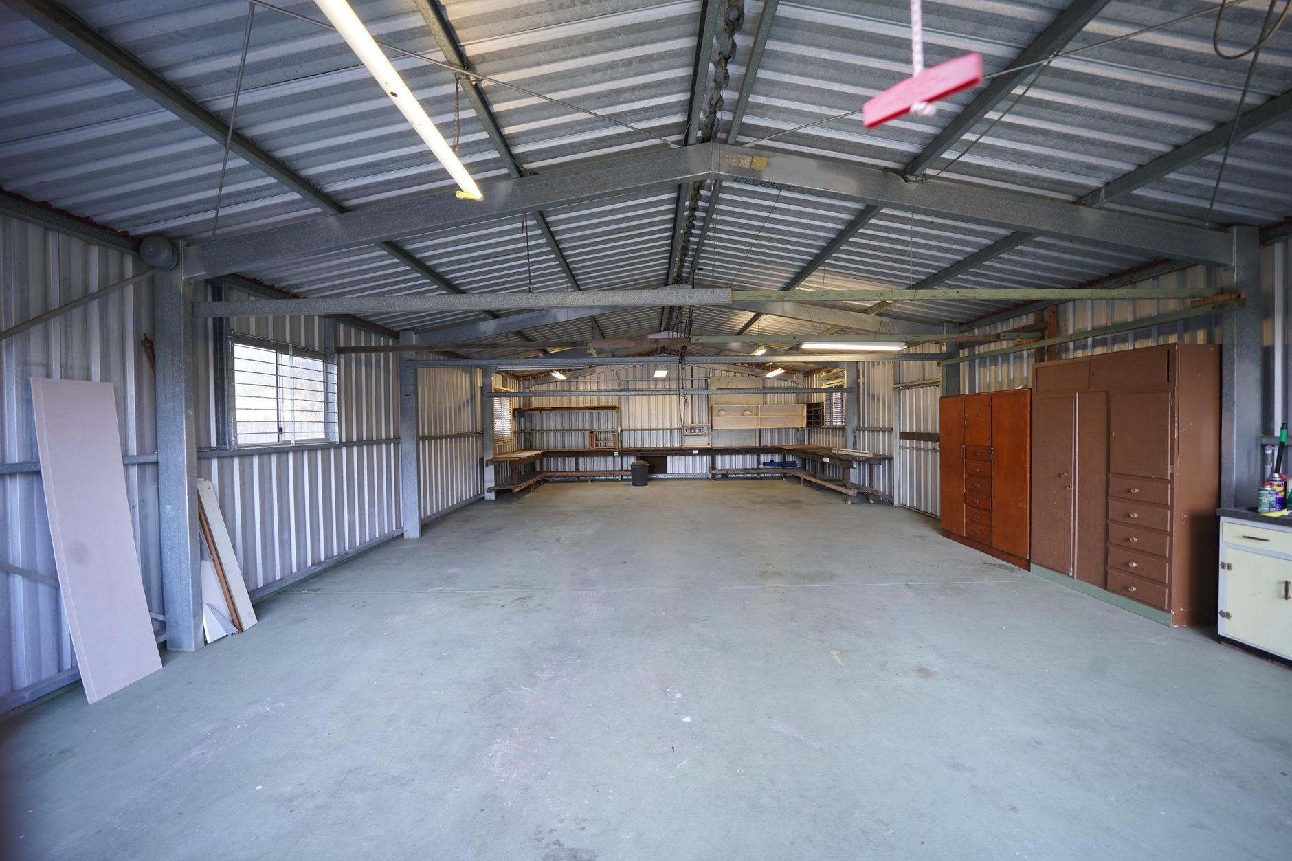 Wide view of a small metal stamping shop floor with presses, material stacks, and clear aisles ready for a press-tending cell.