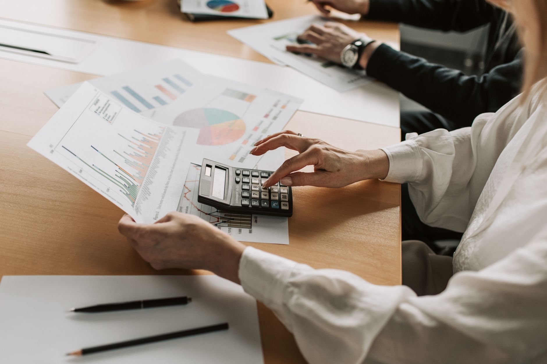 Finance and operations leaders reviewing a budget spreadsheet, the kind of working session where robot chargeback rules get agreed.
