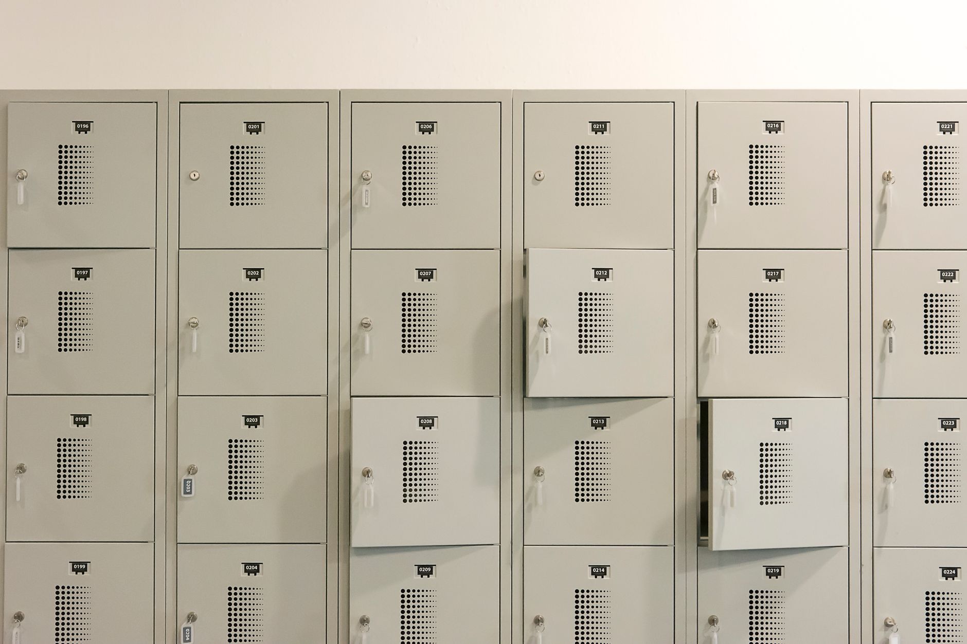 Metal employee lockers lining an industrial changing corridor between shifts.