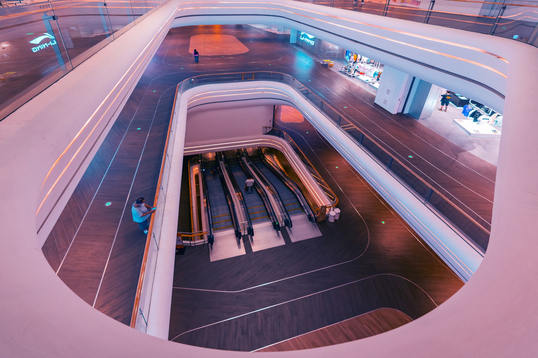 Custodial staff cleaning a broad mall corridor during off-hours, illustrating the base-layer budgeting case for common-area floor care.