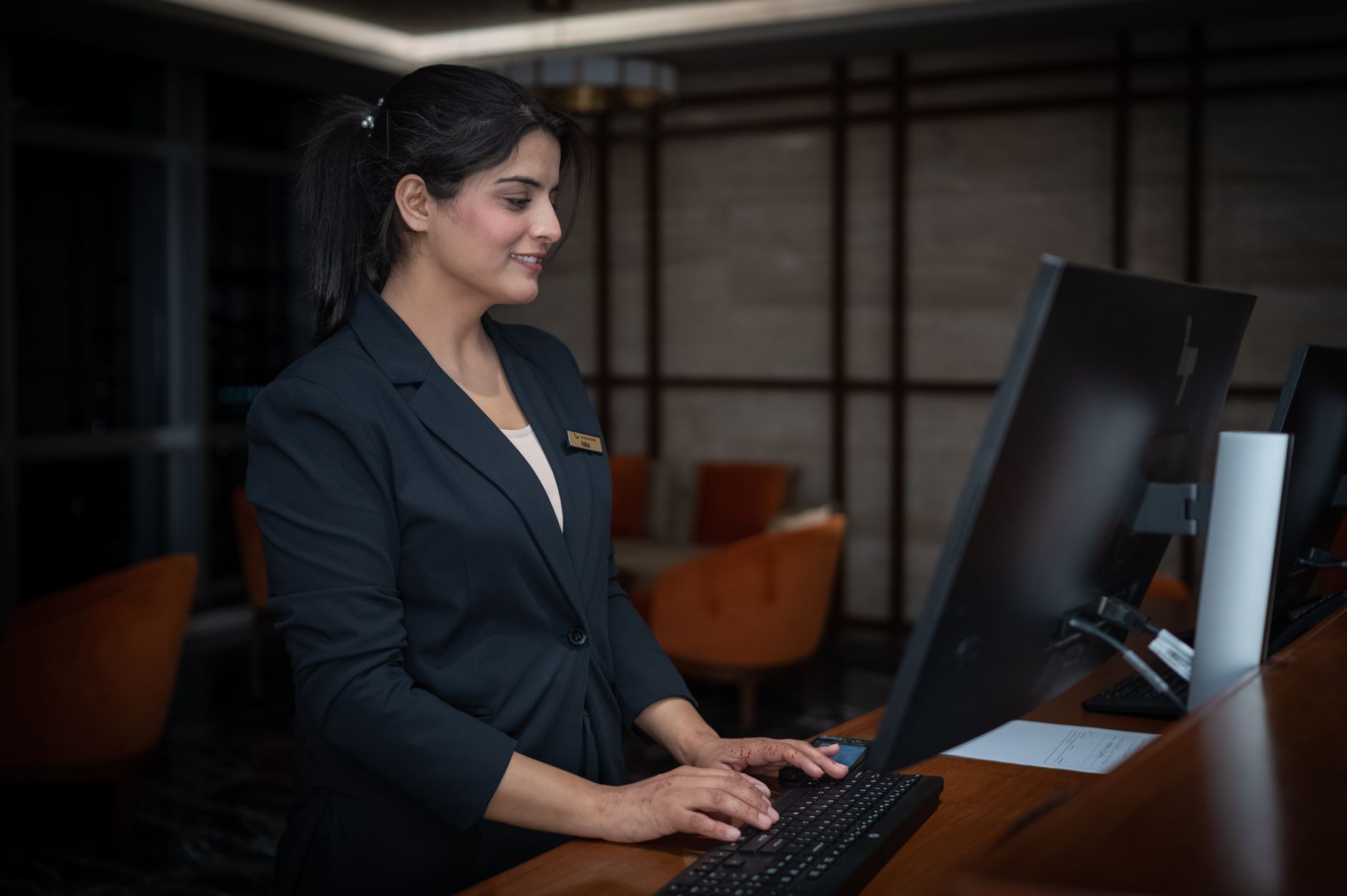 A lightly staffed hotel front desk in the evening, reflecting the labor pressure and overnight coverage challenges described in the budget model.