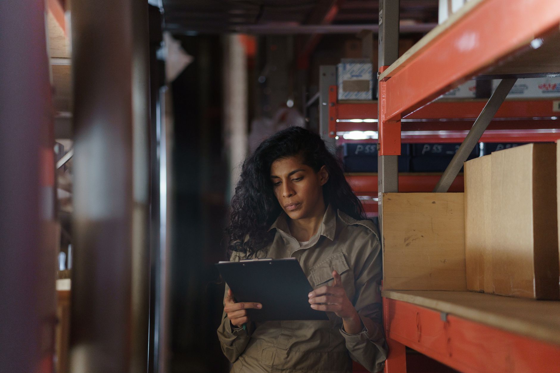 A warehouse worker records observations on a clipboard, reflecting the evidence gathered for a single exception event.