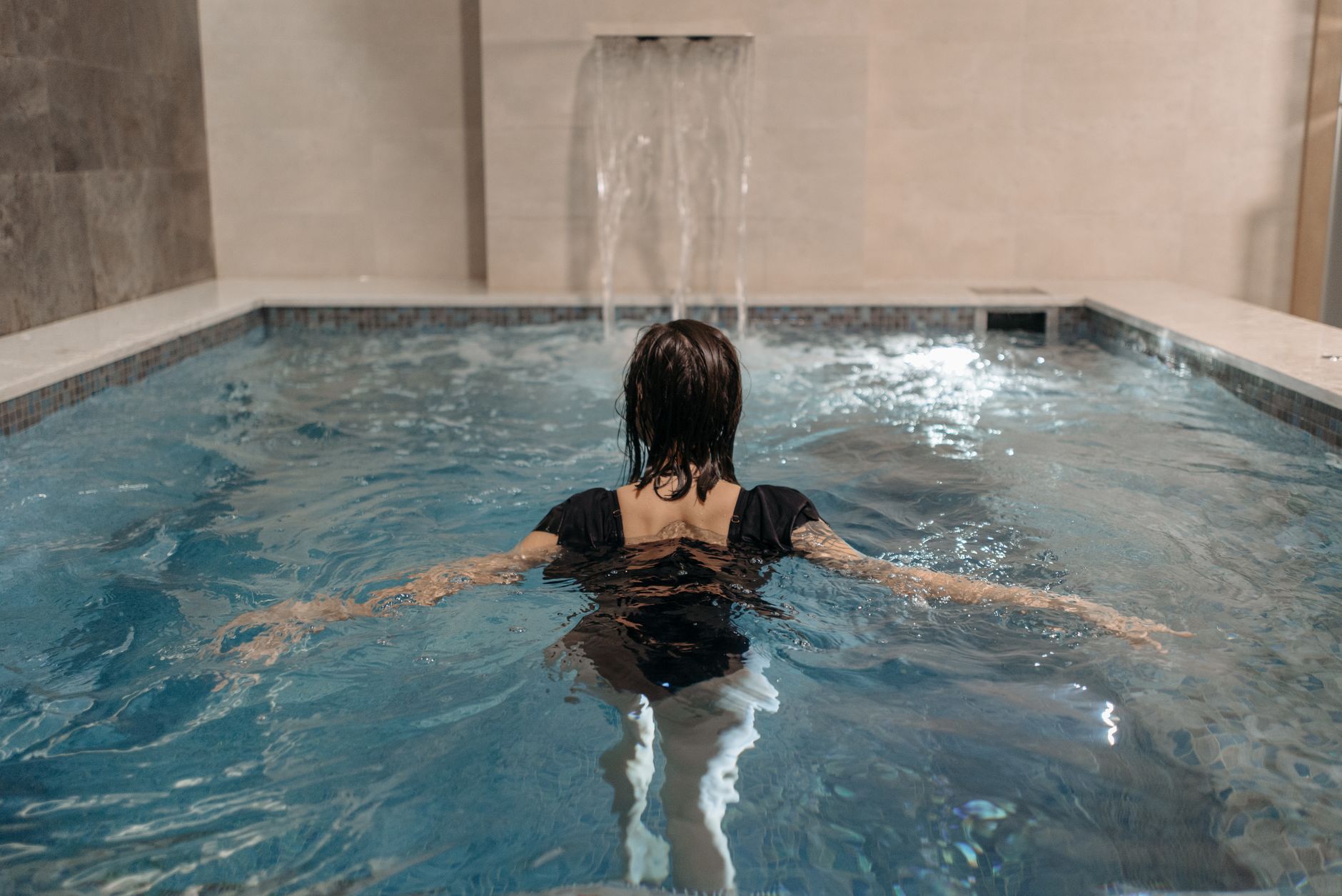 A wet indoor spa pool deck with textured flooring, drains, and transition areas that require careful cleaning.