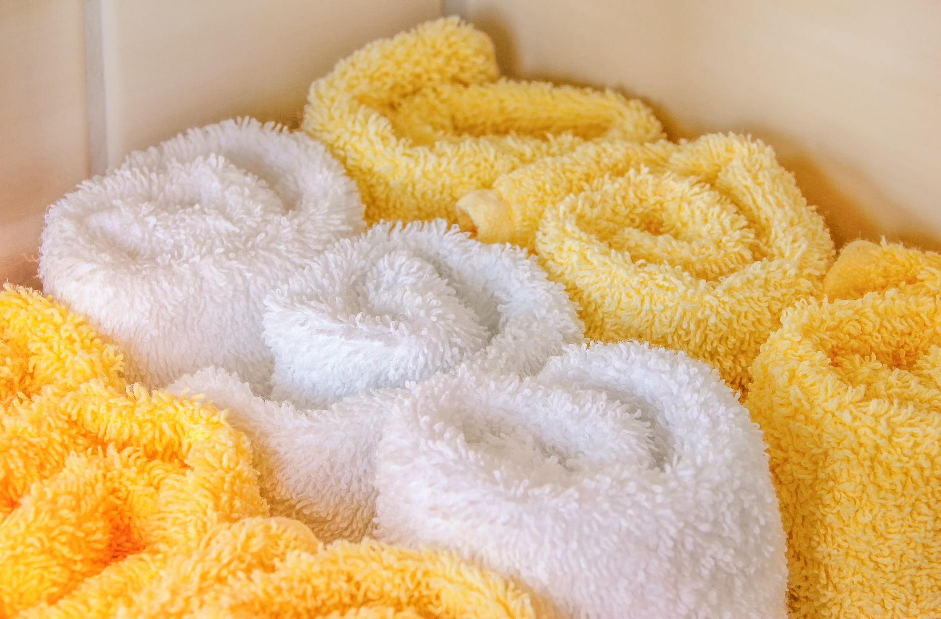 Fresh towels arranged on a cart in a premium spa locker area where cleaning routes must remain clear.