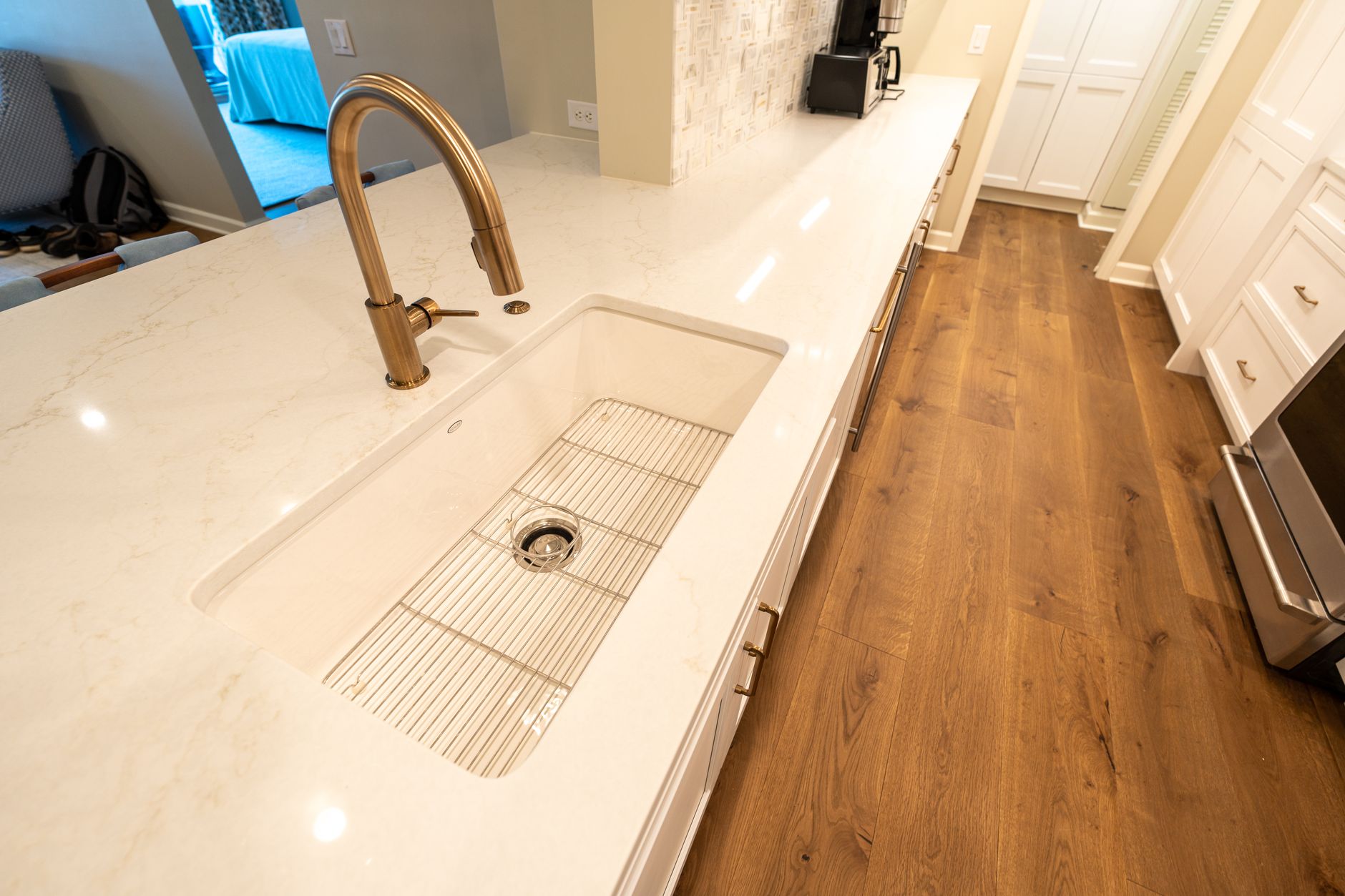 A wet kitchen aisle with a floor drain and uneven transitions that can break traction and water recovery.