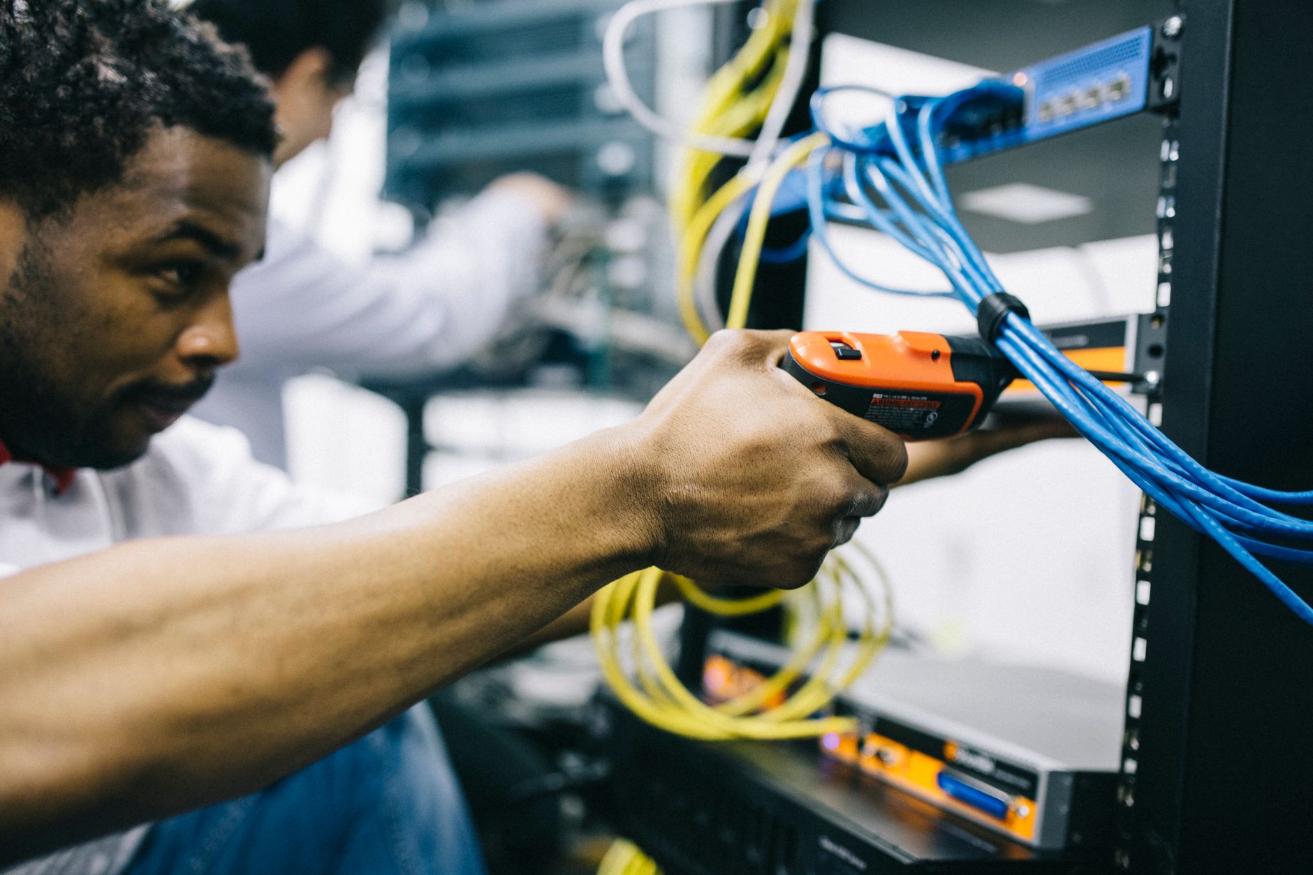 An IT technician inspects a server rack, representing the wireless network audit crucial for robot readiness.