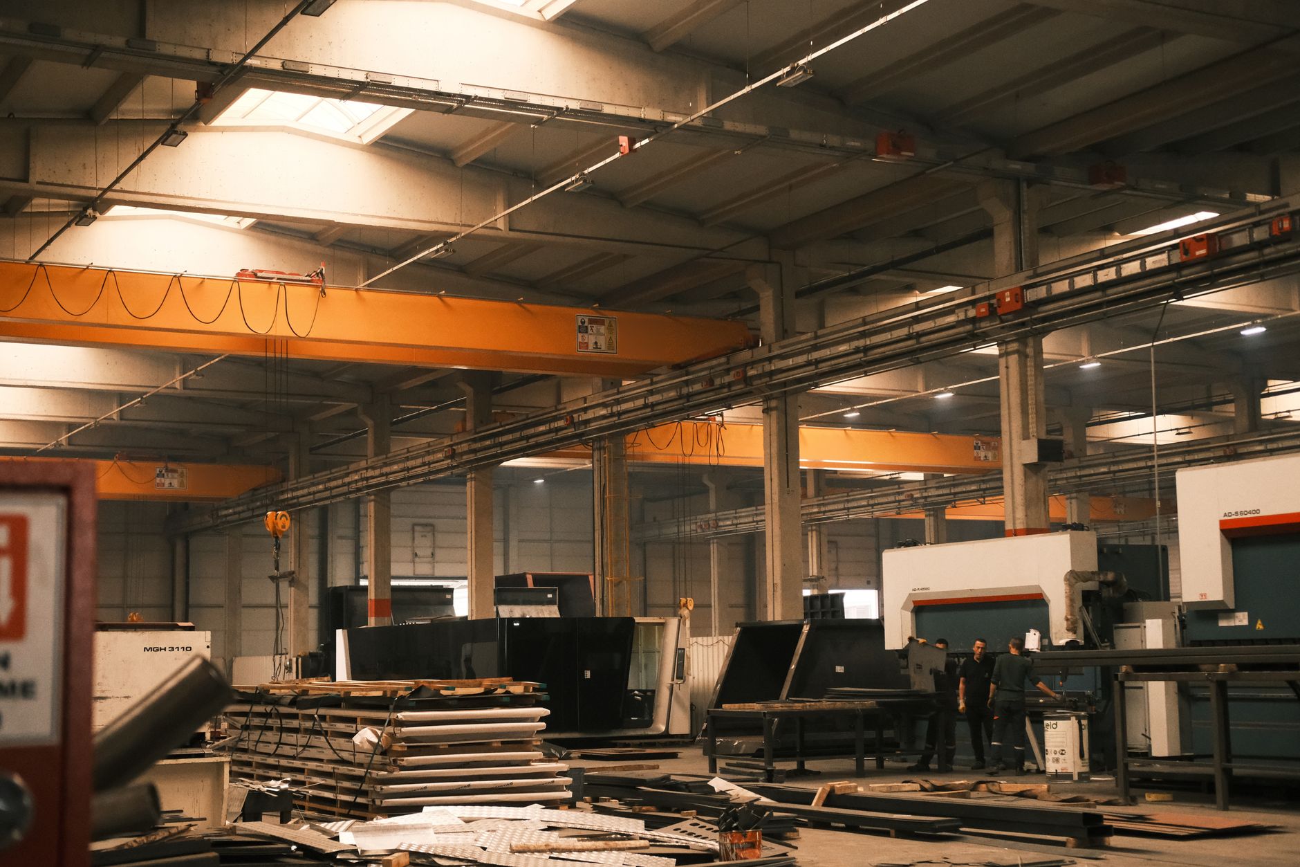 An overhead crane in a factory bay, illustrating zones where AMRs must stop during lifts.