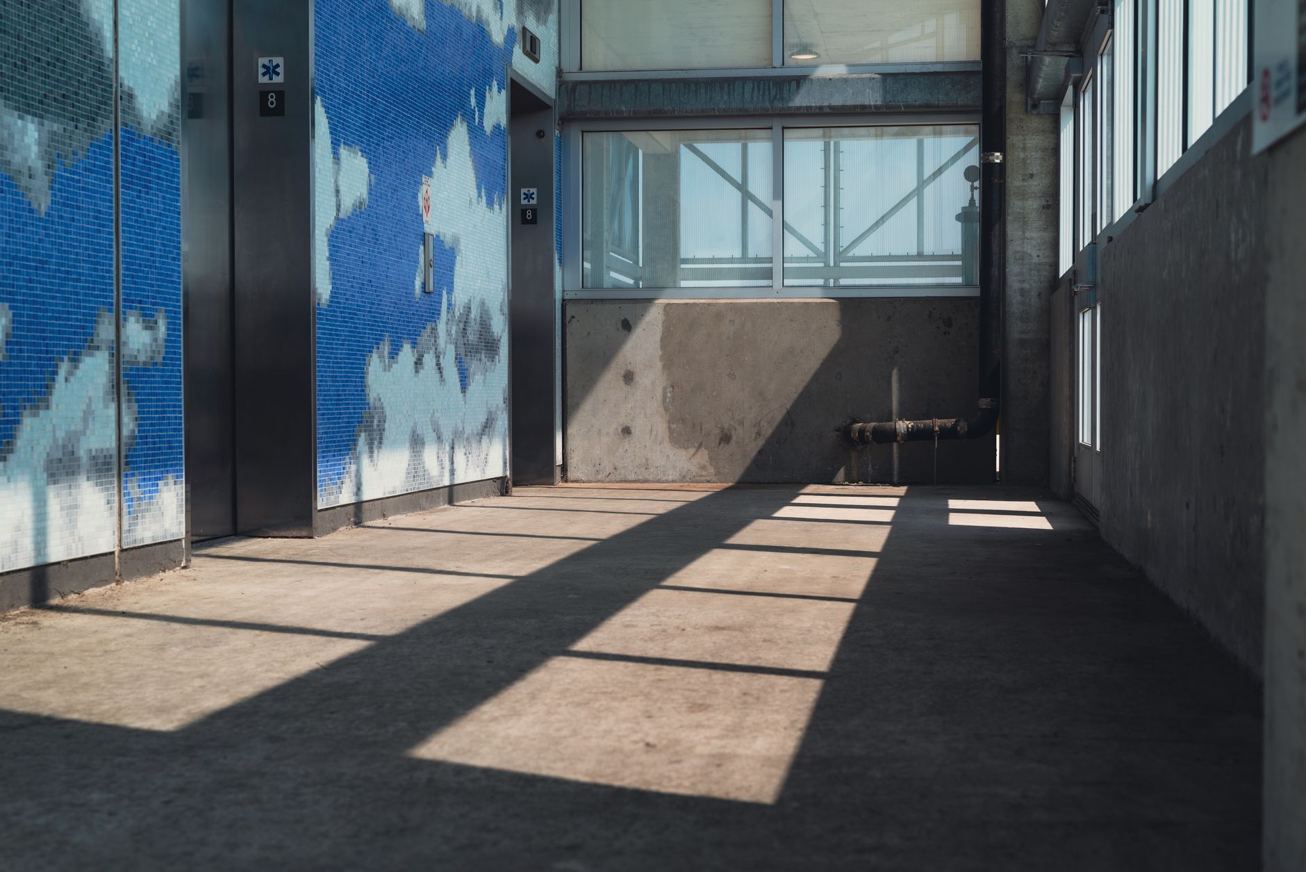 A wide service corridor leading to a freight elevator, showing the kind of predictable, low-drama route a museum would want for controlled internal transport.